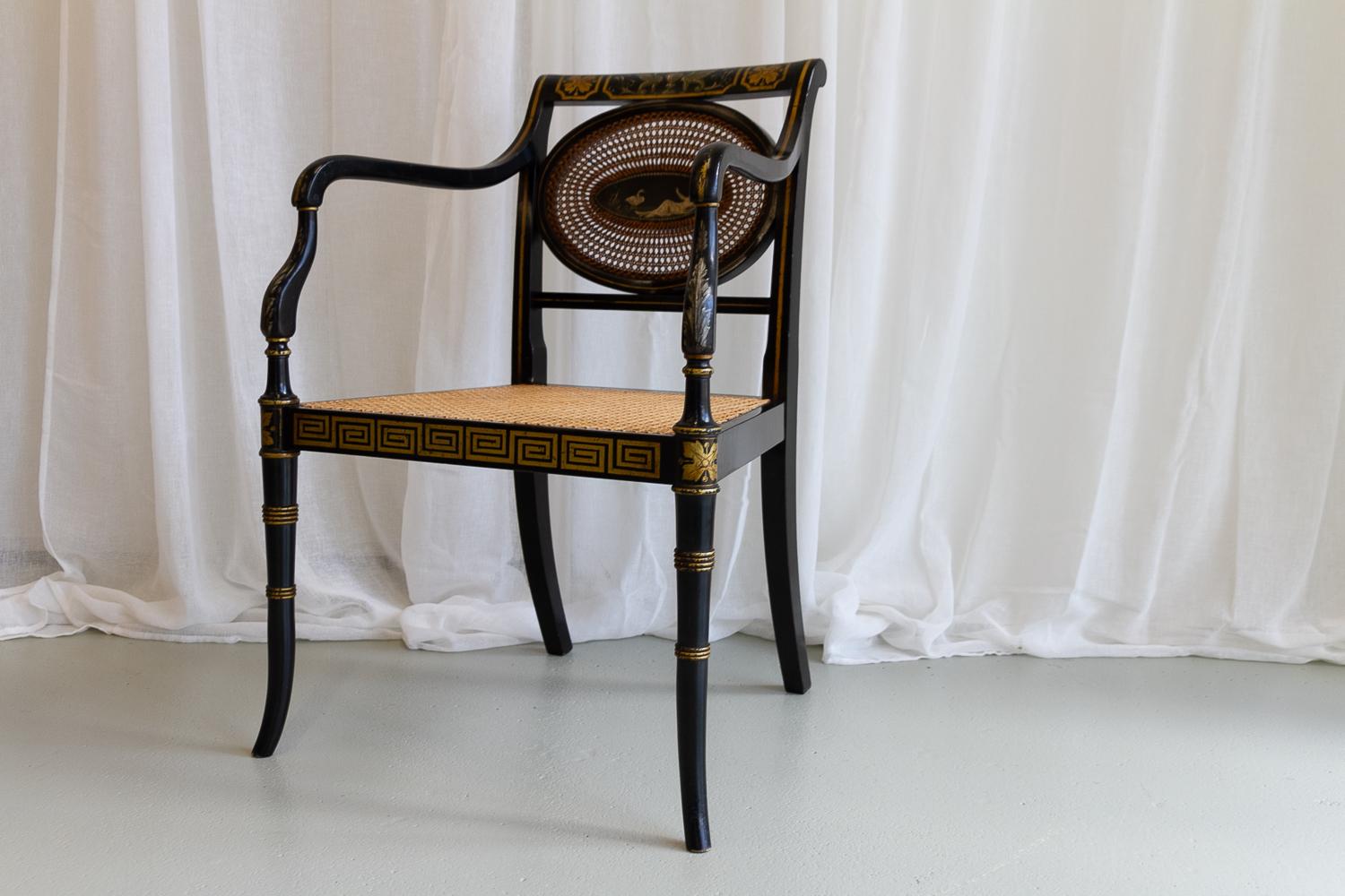 English Regency Black and Gold Armchair, 19th Century.

Antique shield back chair with hand painted reclining nude female and swan motif. The back stretcher is decorated with ornate griffins. Ebonized frame with golden Greek key patterns and