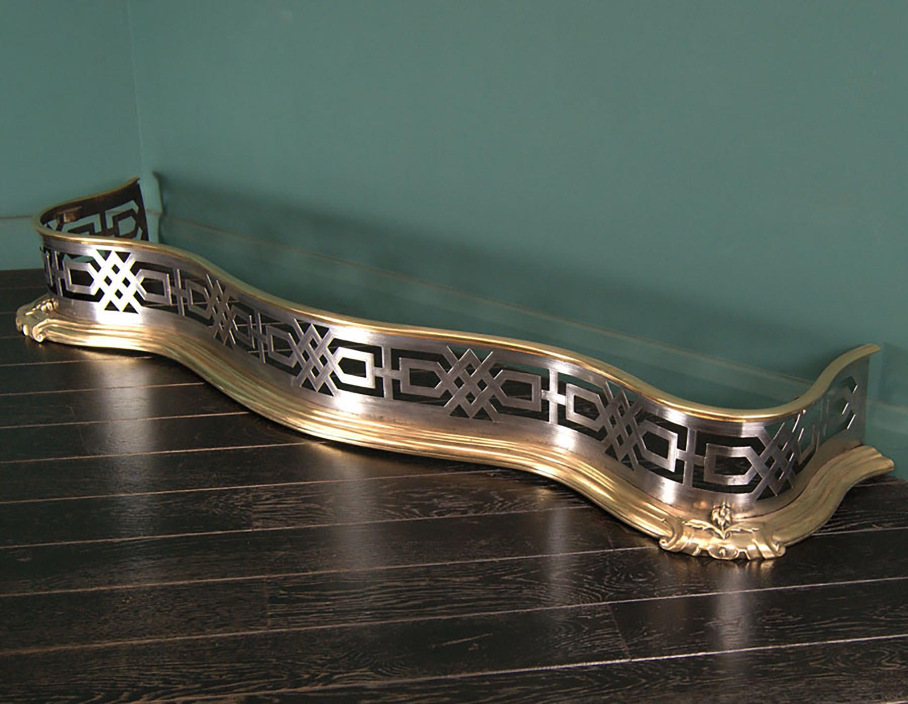 Parafuoco inglese Regency in ottone e acciaio con raffinati trafori a forma geometrica e incisioni lineari, montato su uno zoccolo in ottone e collare in ottone nella parte superiore. 
Gli angoli esterni presentano un unico dettaglio floreale