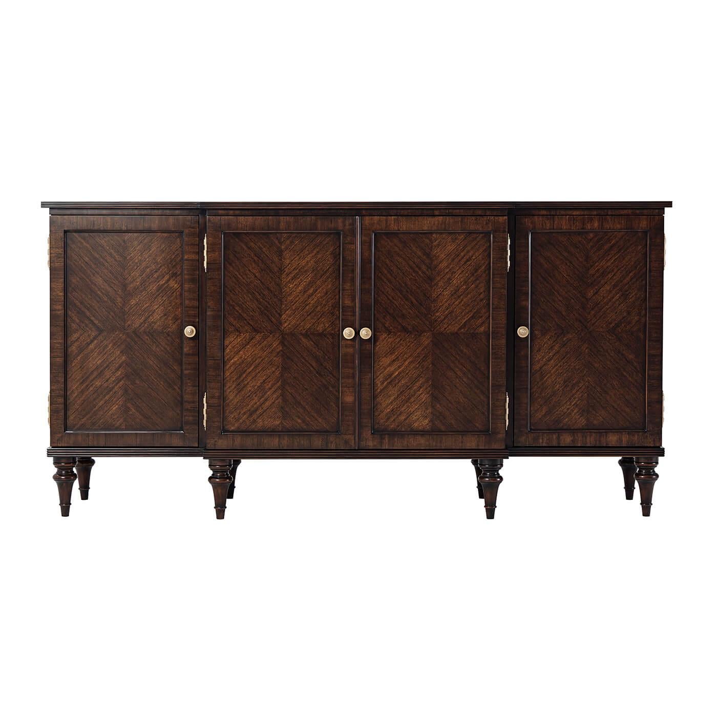 English Regency style breakfront credenza with feathered Paldoa veneers, a breakfront with a reeded edge top, with four recessed panel doors enclosing shelves and two drawers, with a reeded frame base and raised on turned and tapered