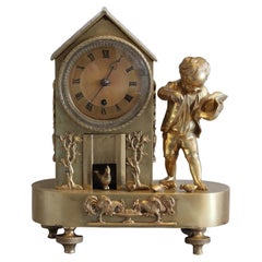 Reloj de chimenea "Género" de bronce de la Regencia inglesa de un niño alimentando gallinas