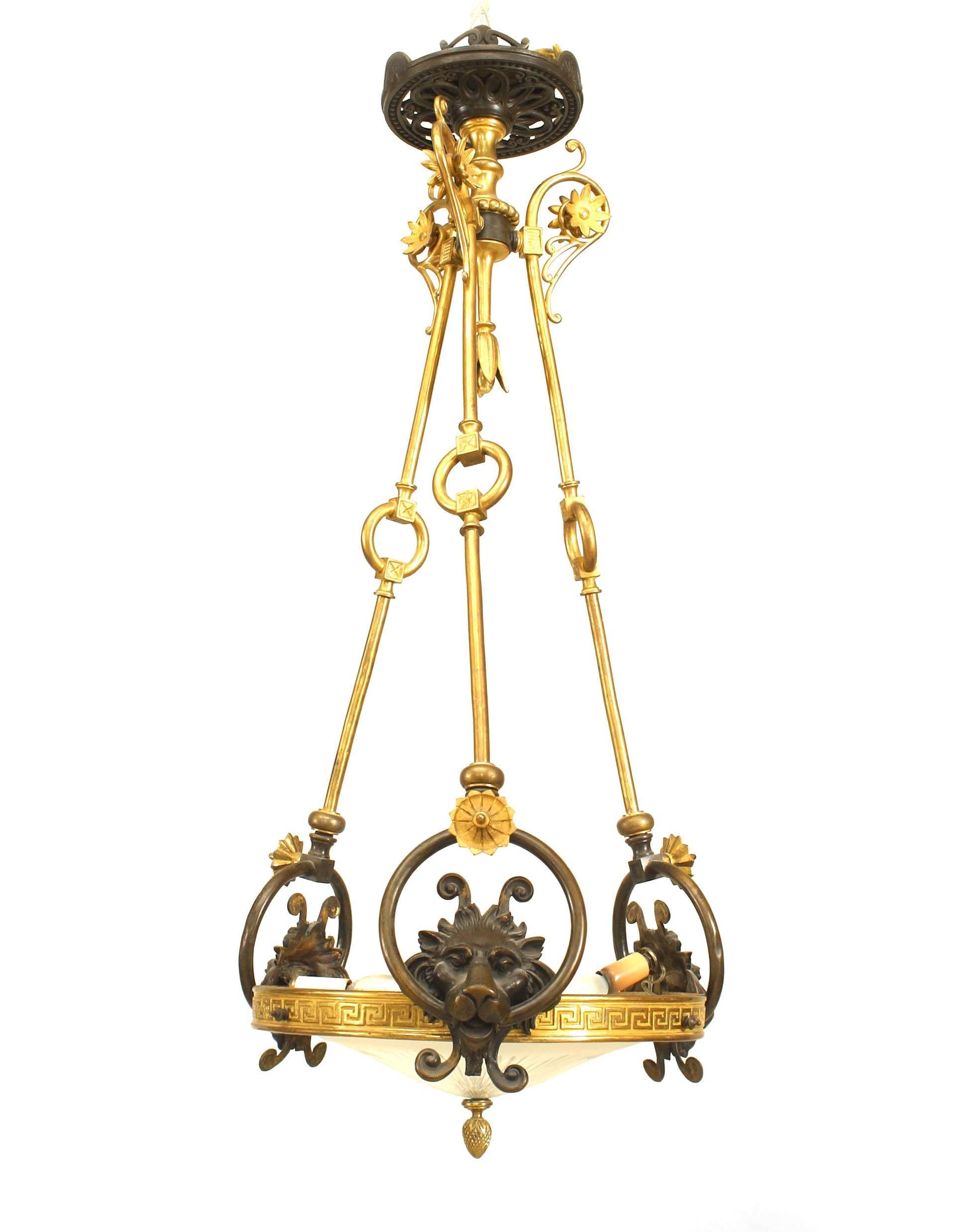 Bronze English Regency pendant chandelier comprised of a circular cut glass shade placed within a Greek key frame and suspended from decorative rods featuring three lion heads support links.
