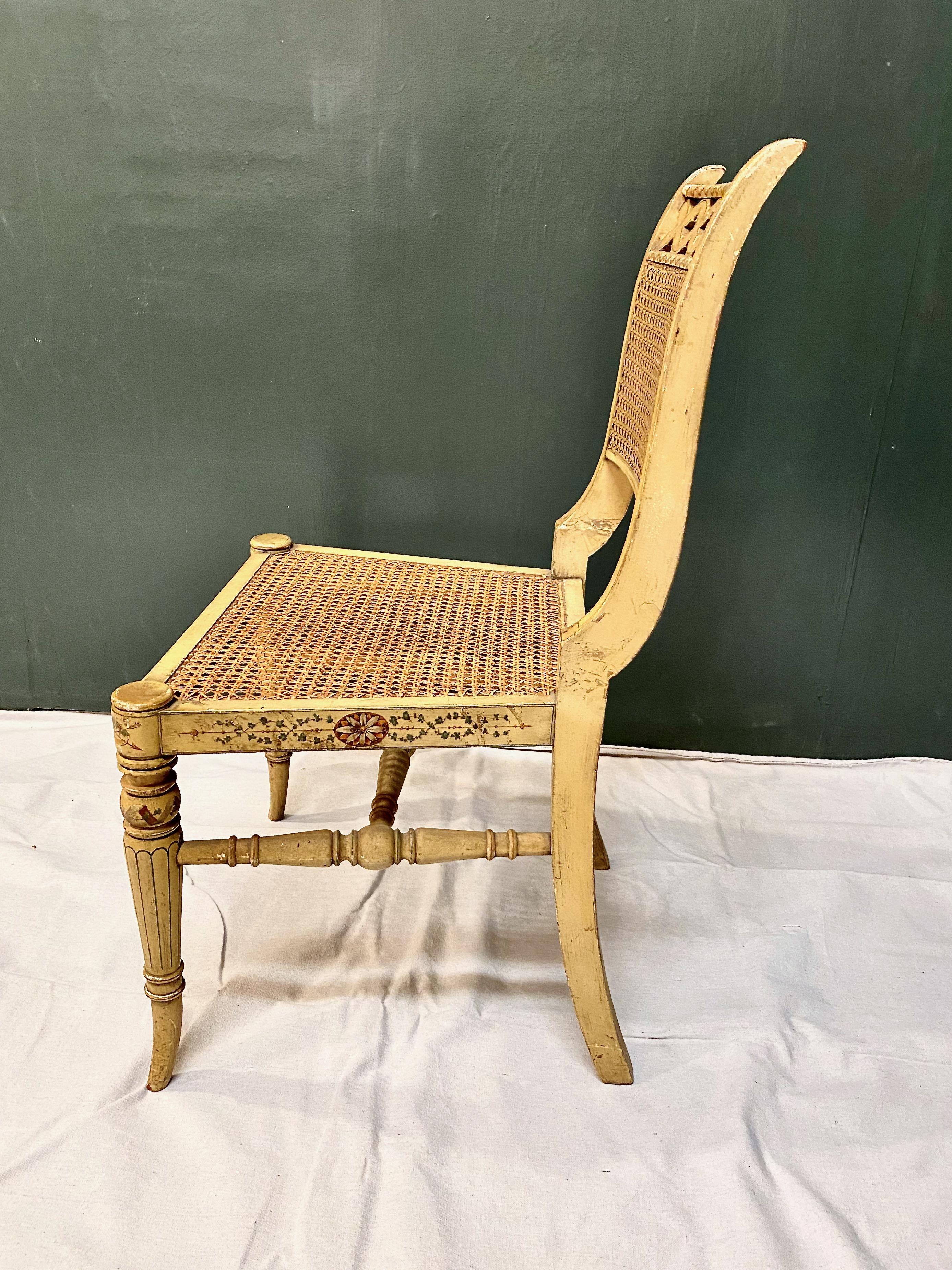 This is a very decorative period English Regency painted and caned side chair. The chair retains its old desirable original painted surface and caning. After nearly two hundred years of use it is still sturdy and ready to roll.
