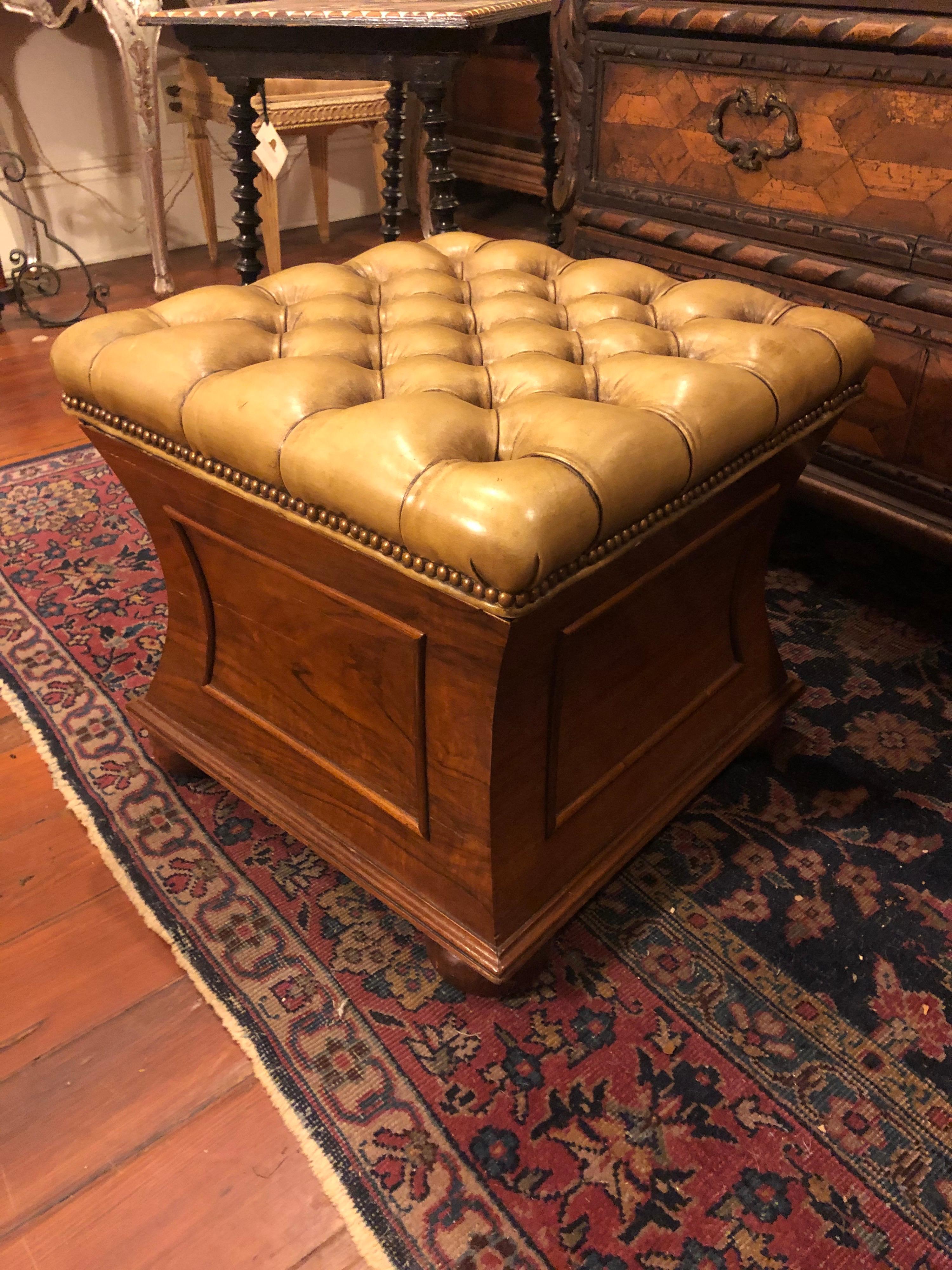 English regency stool with paneled concave sides and tufted leather top that opens for a storage box.