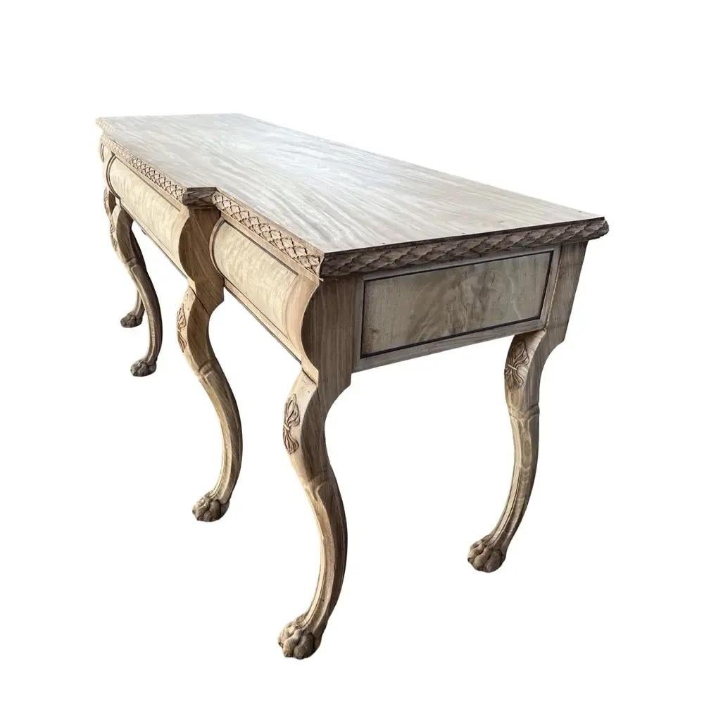 Console table hand-made in England in the early 1800s using mahogany and decorated with mahogany veneer. The console presents six hand-carved legs sitting on paw feet. The sides and front of the three drawers are decorated with mahogany veneer. The