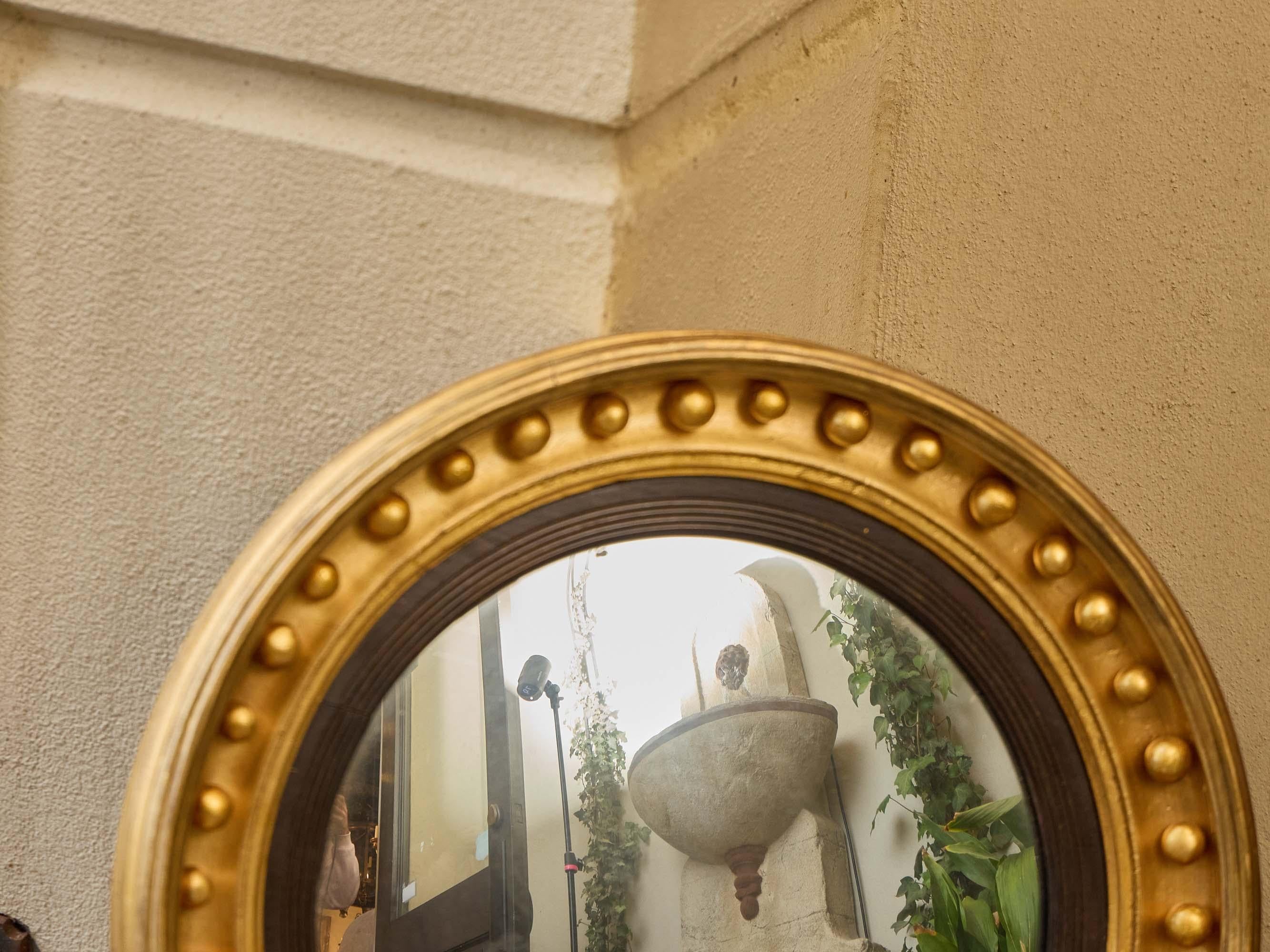 Carved English Regency Convex Giltwood Mirror with Ebonized Reeding, 19th Century For Sale