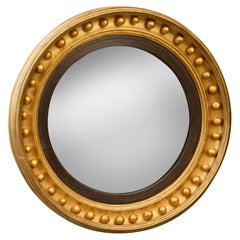 Specchio inglese Regency convesso in legno dorato con bordatura ebanizzata, XIX secolo
