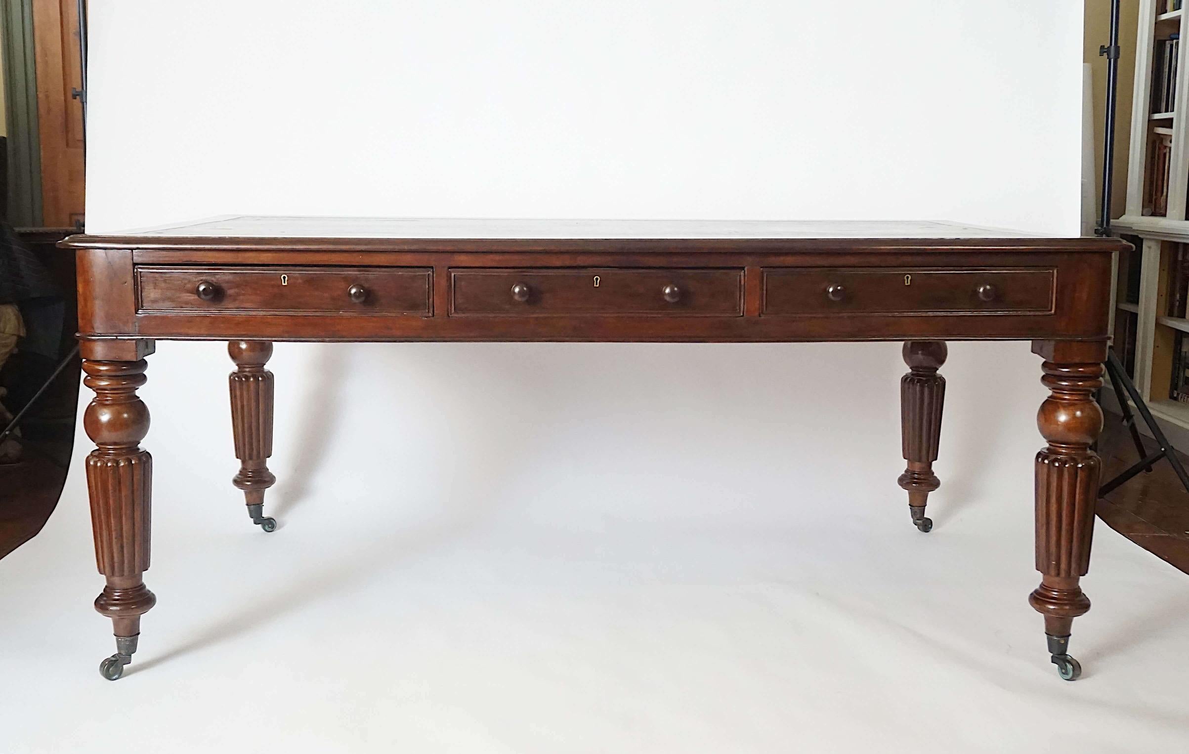 Mesa de escritorio o biblioteca de doble cara de caoba maciza, de la época de la regencia inglesa de hacia 1830, Jorge IV / Guillermo IV, de gran tamaño y forma rectangular, con tapa de cuero negro, posiblemente original, insertada sobre largos