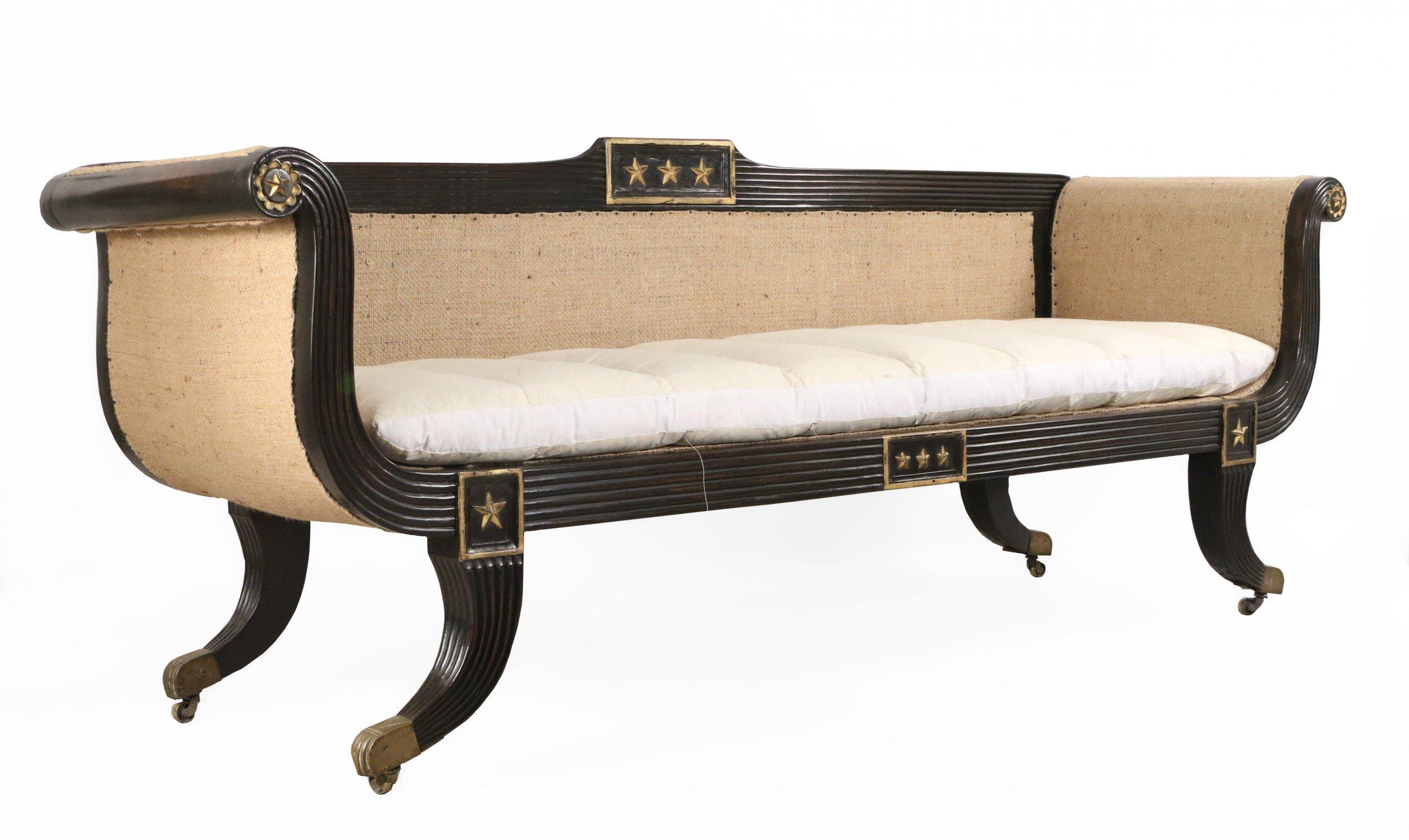 Englisches Regency-Sofa mit ebonisiertem und geriffeltem Rahmen, 3 Sitze mit vergoldeten Verzierungen und unbearbeiteten, gepolsterten Seiten und Rücken mit einem losen, baumwollbezogenen Kissen, das auf Messingrollen ruht.
 