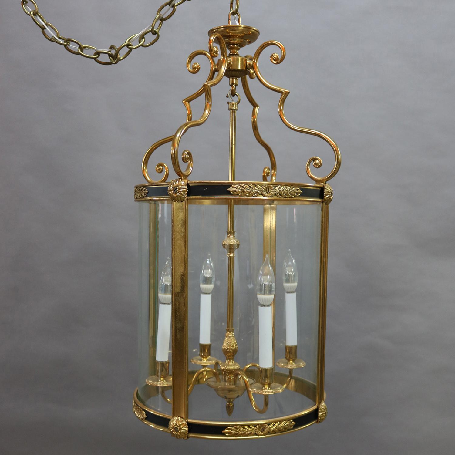 English Regency style pendant chandelier features lantern form having bronze frame with ebonized panels and cast foliate attachments housing four curved glass panels which surround candle lights and is supported by scroll form arms, 20th