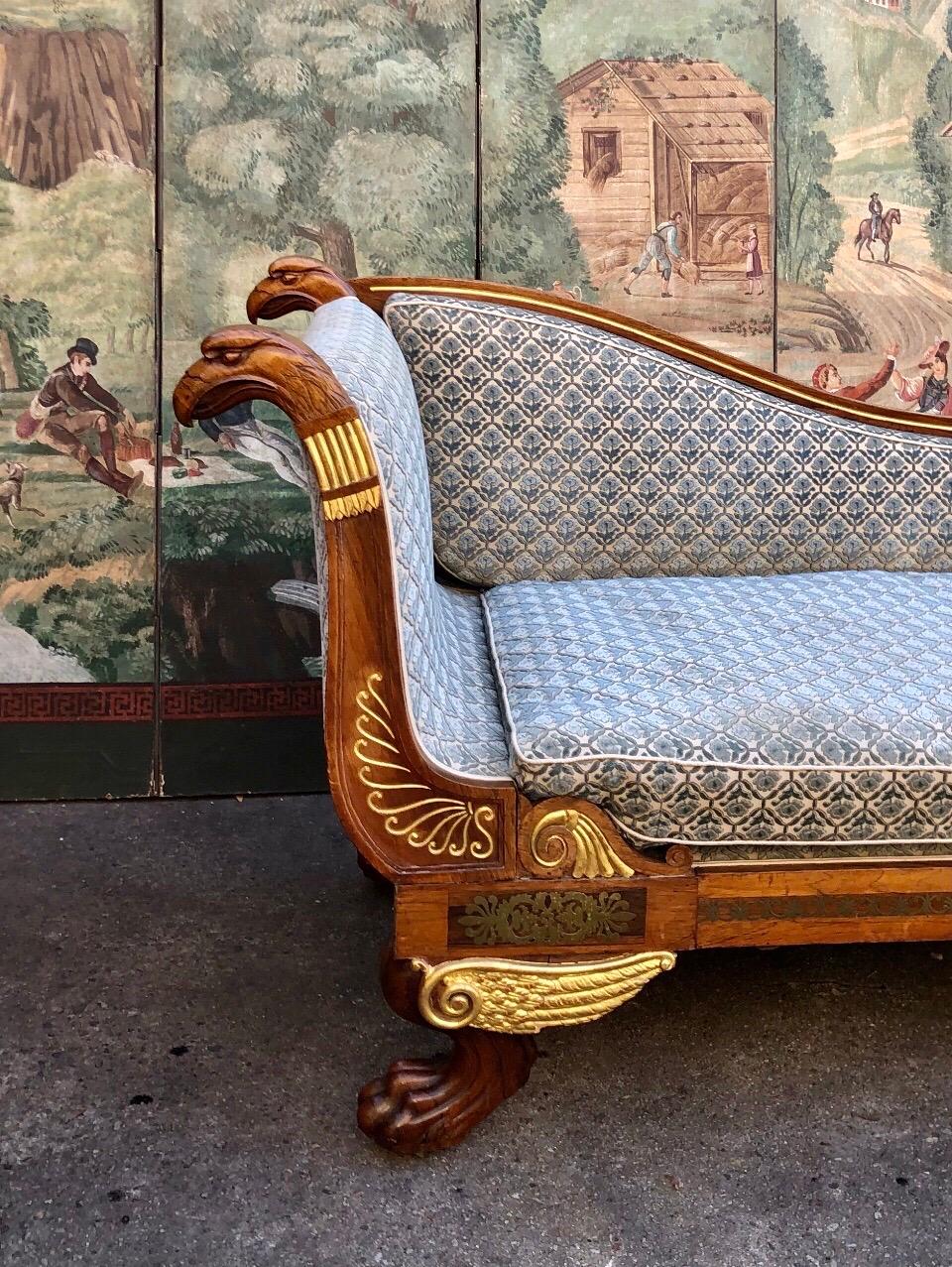 English Regency Egyptian revival style mahogany, brass inlay, & gilt Recamier is finely carved with an Egyptian hawk head and finished on both sides.