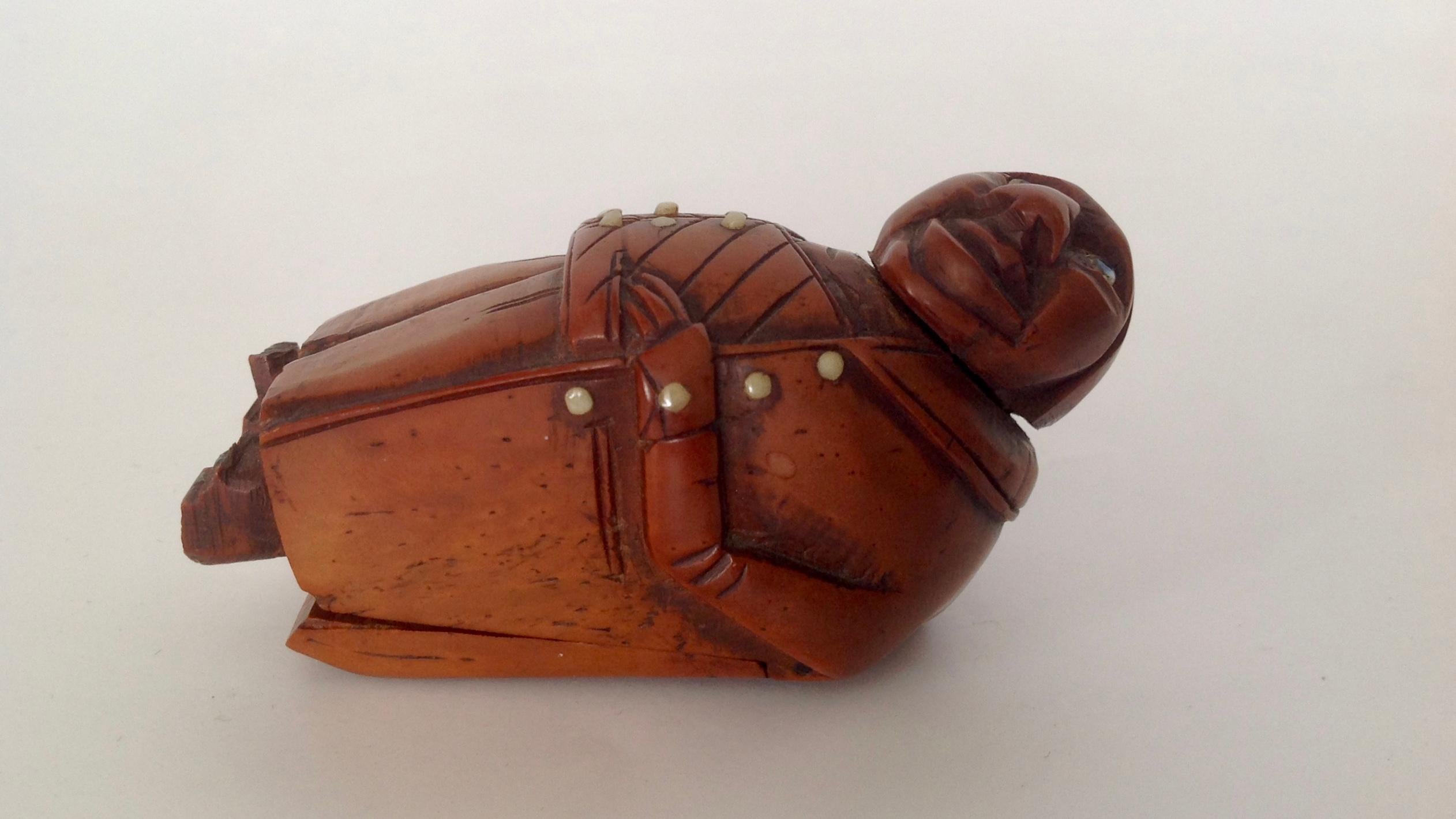 Carved in the form of a figure from a Charles Dickens novel - the whimsical figure is designed
with a coat tail that lifts revealing the secret compartment.
The eyes and buttons appear to be glass.