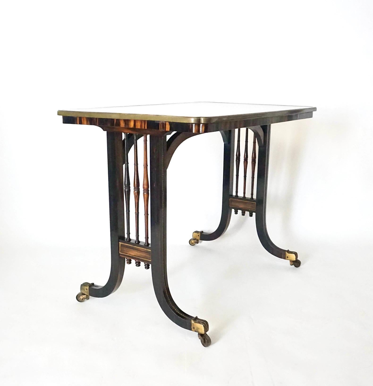 An exceptional circa 1820 English regency period rectangular-form writing or occasional table attributed to Gillows having brass bound cusped-corner top with ebony line inlay and satinwood feather-banding surrounding center field of bookmatched