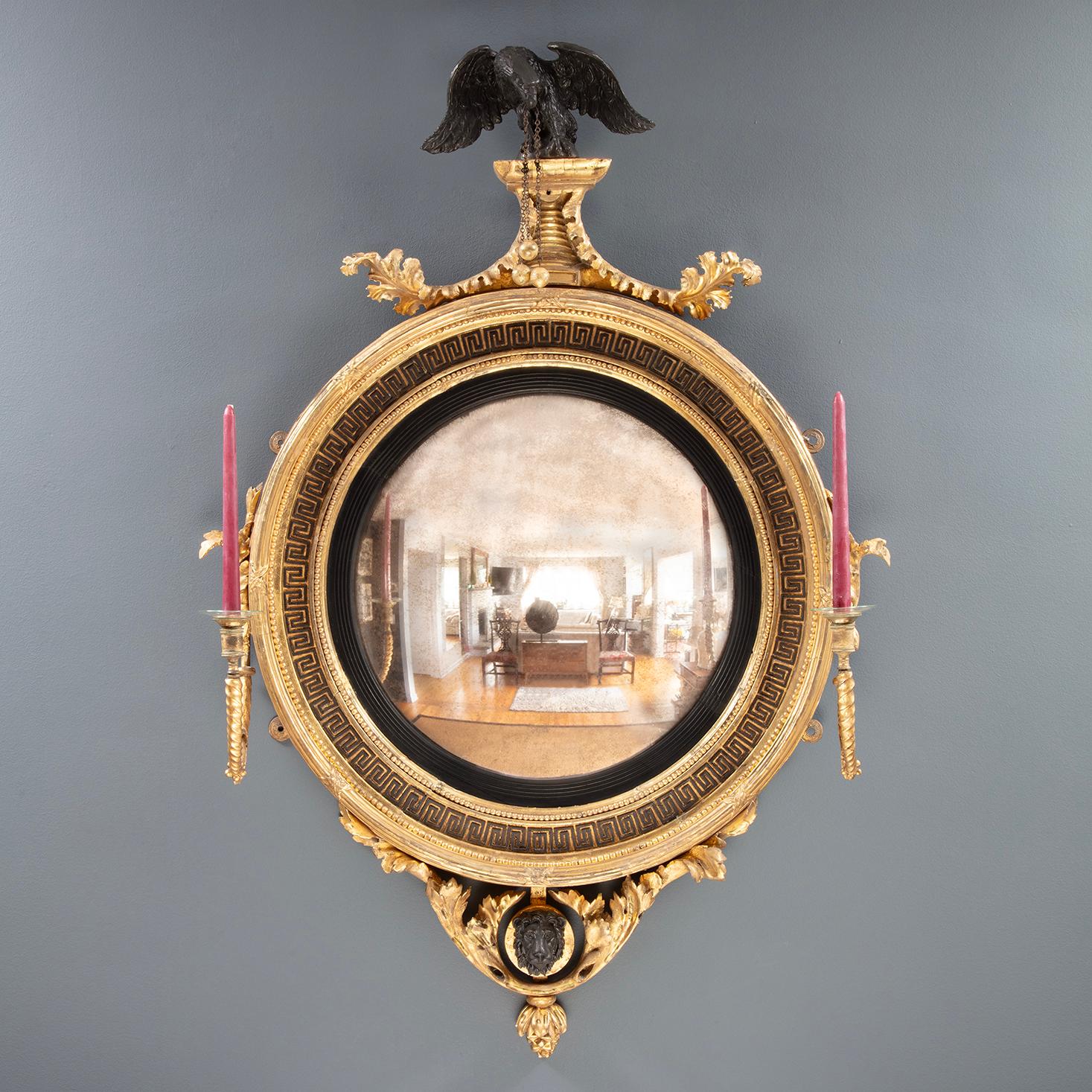 Specchio Girandole convesso inglese dorato. Circa 1810. Alla maniera di Thomas Fentham.

Aquila ebanizzata, faccia di leone e decorazione a chiave greca. Piastra a specchio originale. Ex famiglia Goddard. Thomas Ives House, Providence, RI.

32″l x