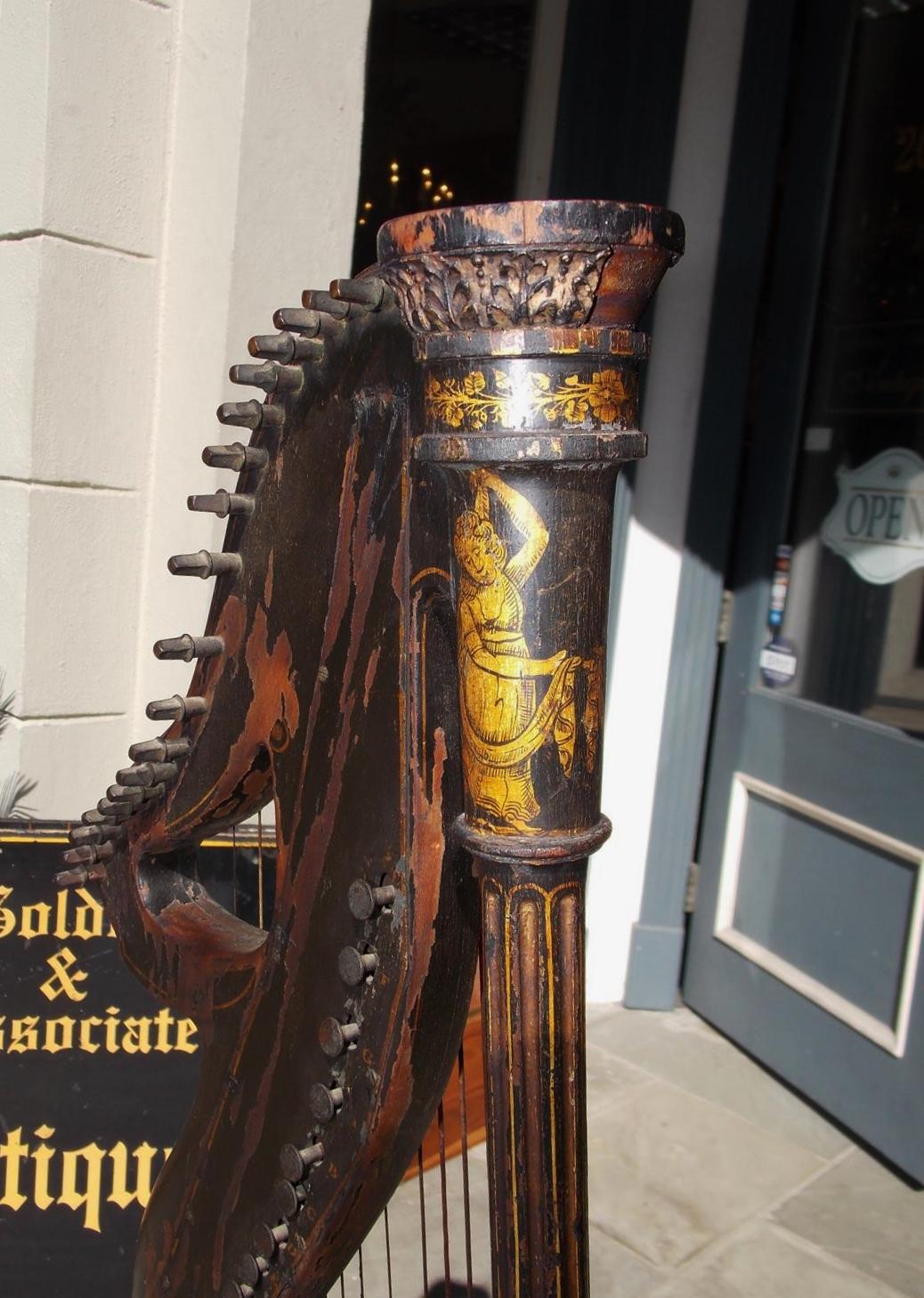 English Regency gilt stenciled figural and floral ebonized dital harp signed by maker Edward Light. Retailed at Srohl Foley place London, Early 19th century.