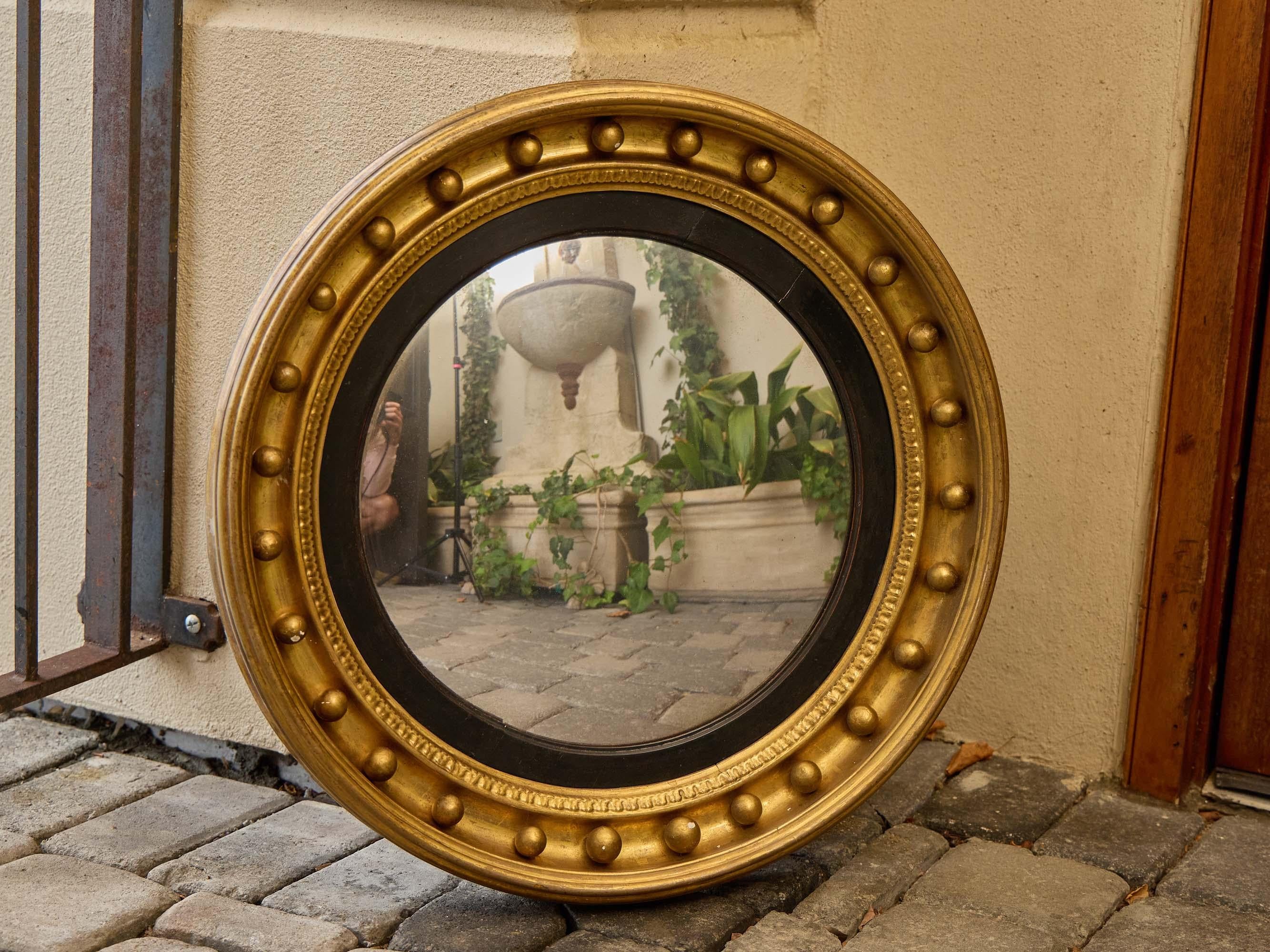 Inglese Specchio convesso in legno dorato inglese Regency con finiture ebanizzate, XIX secolo in vendita