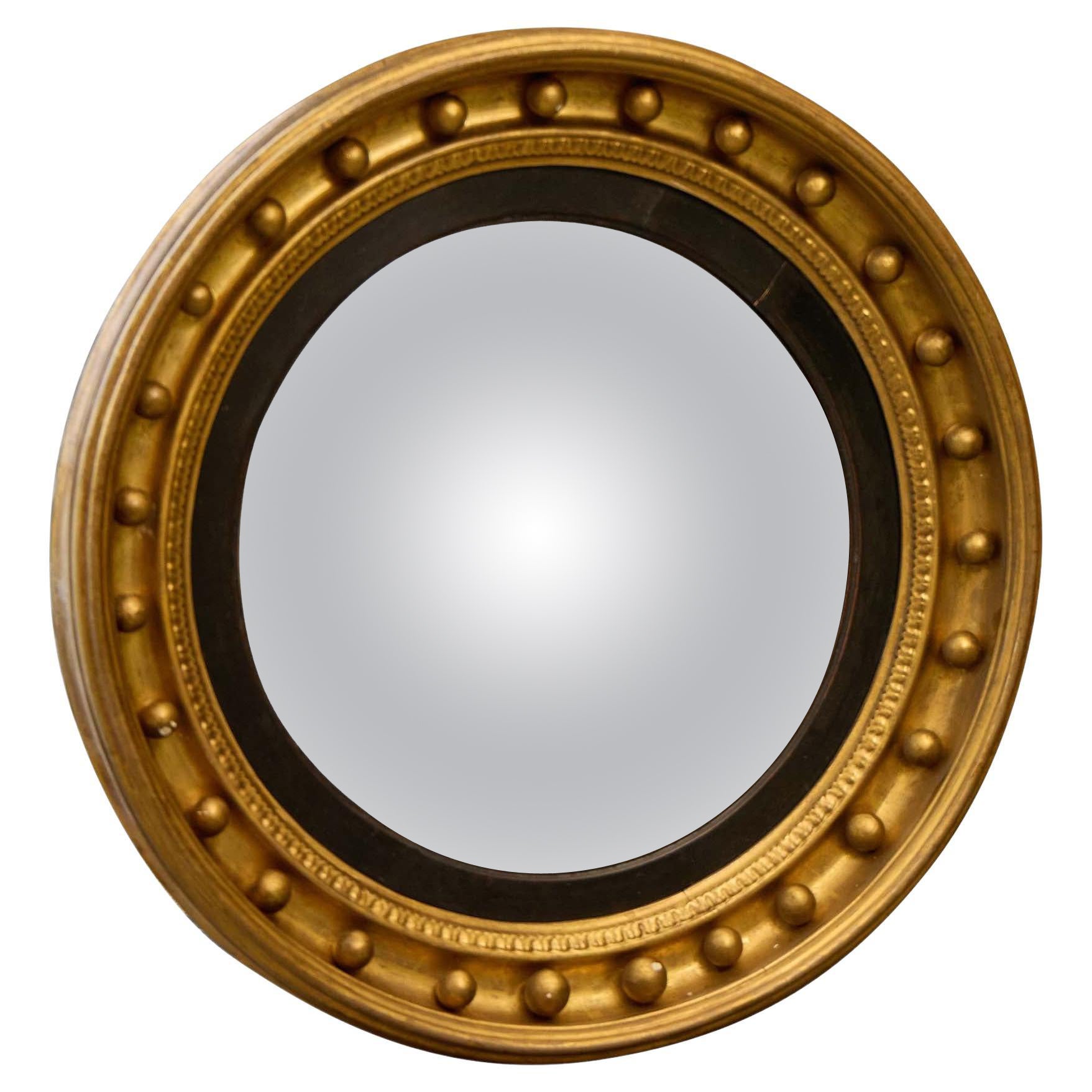 Specchio convesso in legno dorato inglese Regency con finiture ebanizzate, XIX secolo