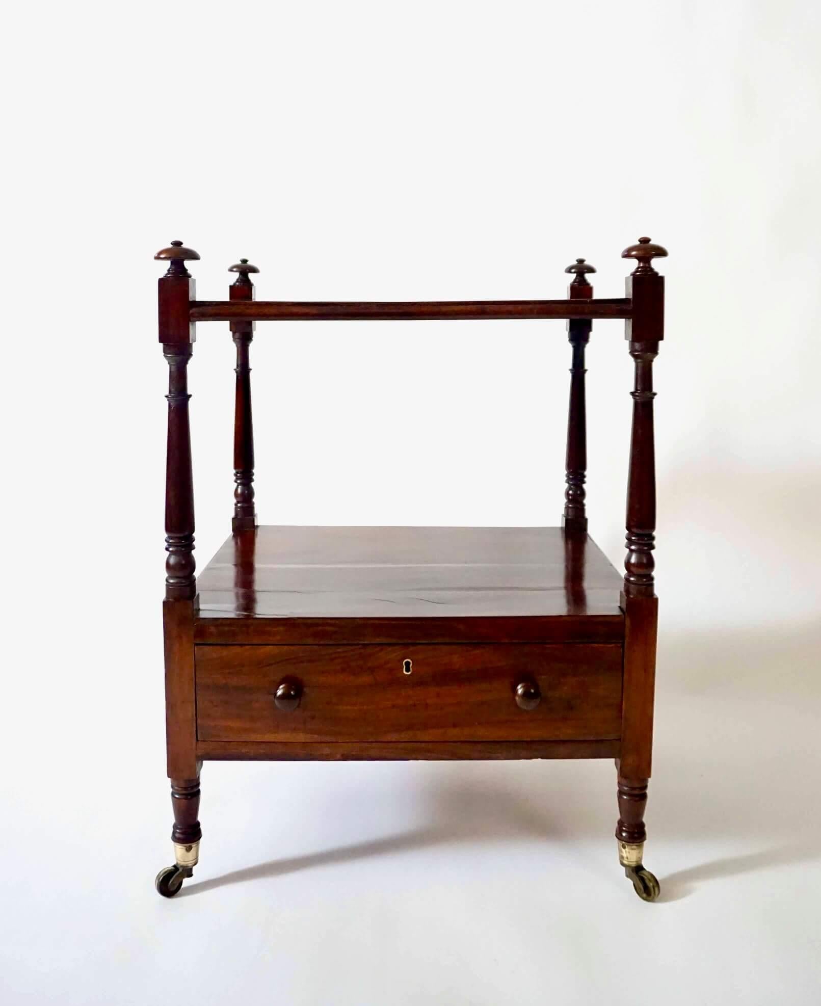 An unusually fine English Regency circa 1815 'Gonçalo alves' or 'Kingwood' library stand, dwarf etagere, or whatnot of rectangular two-tier form, the top and lower section with drawer supported by turned finial-topped stiles ending in original brass