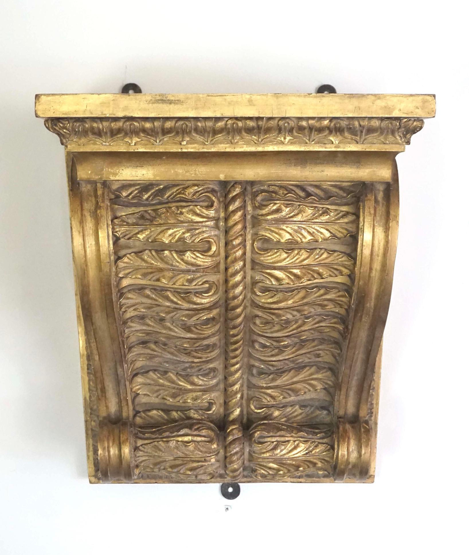 A rare, exceptional, and monumentally scaled circa 1825 English Regency George IV period giltwood wall bracket or shelf of corbel form having rectangular plinth shelf above double spiral acanthus, lotus, and rope motif support. Originally used as a