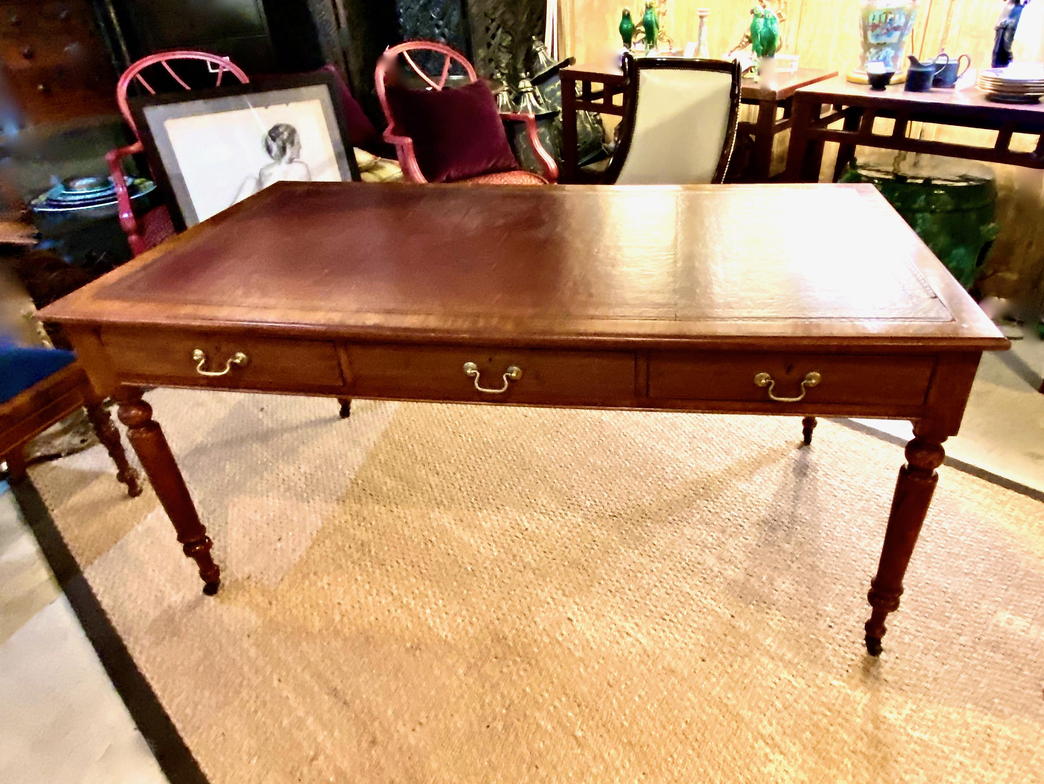 This is a classic English mahogany 3-drawer writing table. The table is in overall very good condition. Although the drawer brasses are replacements, all other elements of the writing table appear to be original. The rich rust-colored leather
