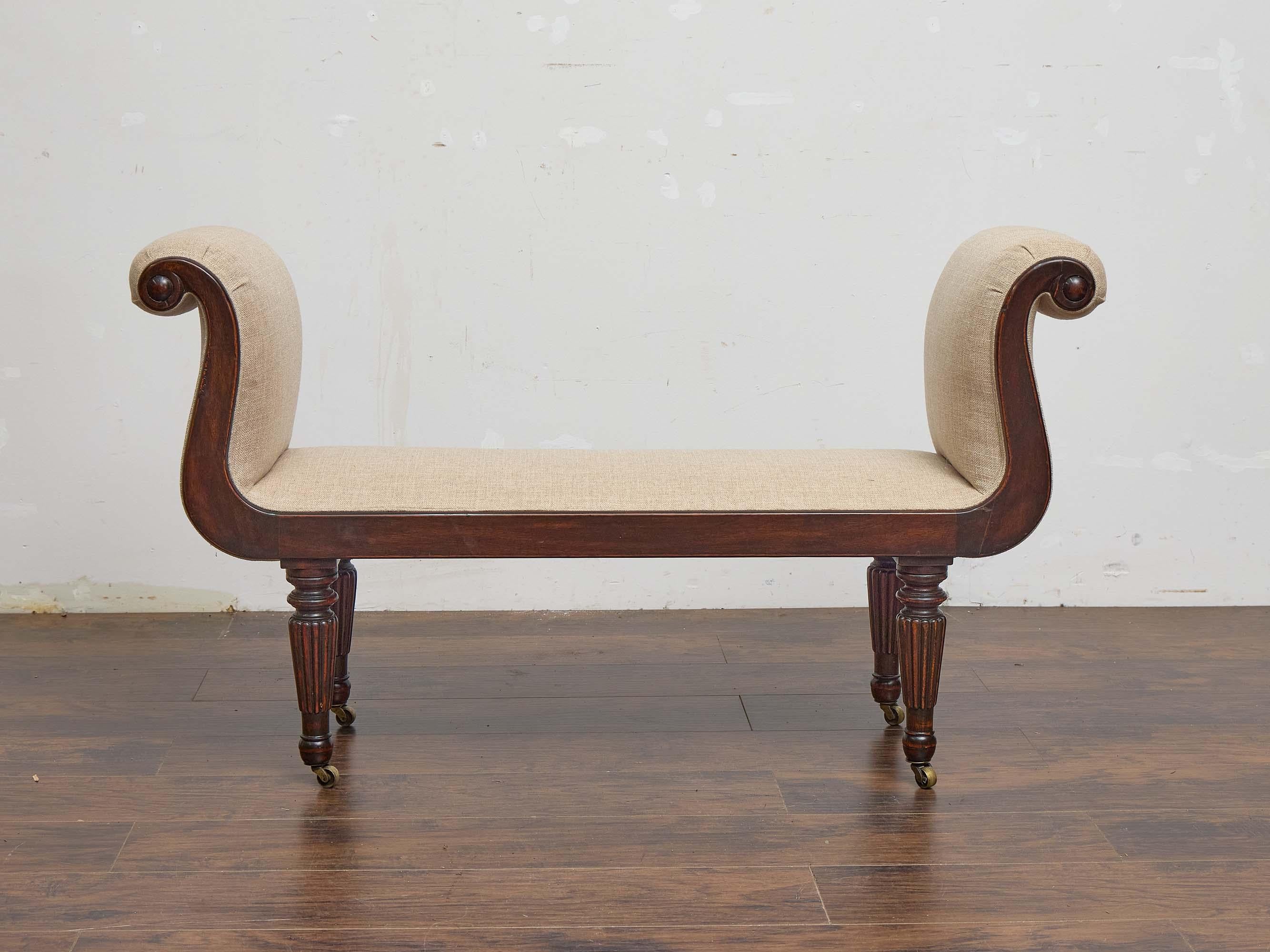 This English Regency mahogany bench from the early 19th century is a timeless accent with classical elegance and restrained detailing. Designed with scrolled arms that curve in a fluid S-shape, the bench combines architectural form with understated