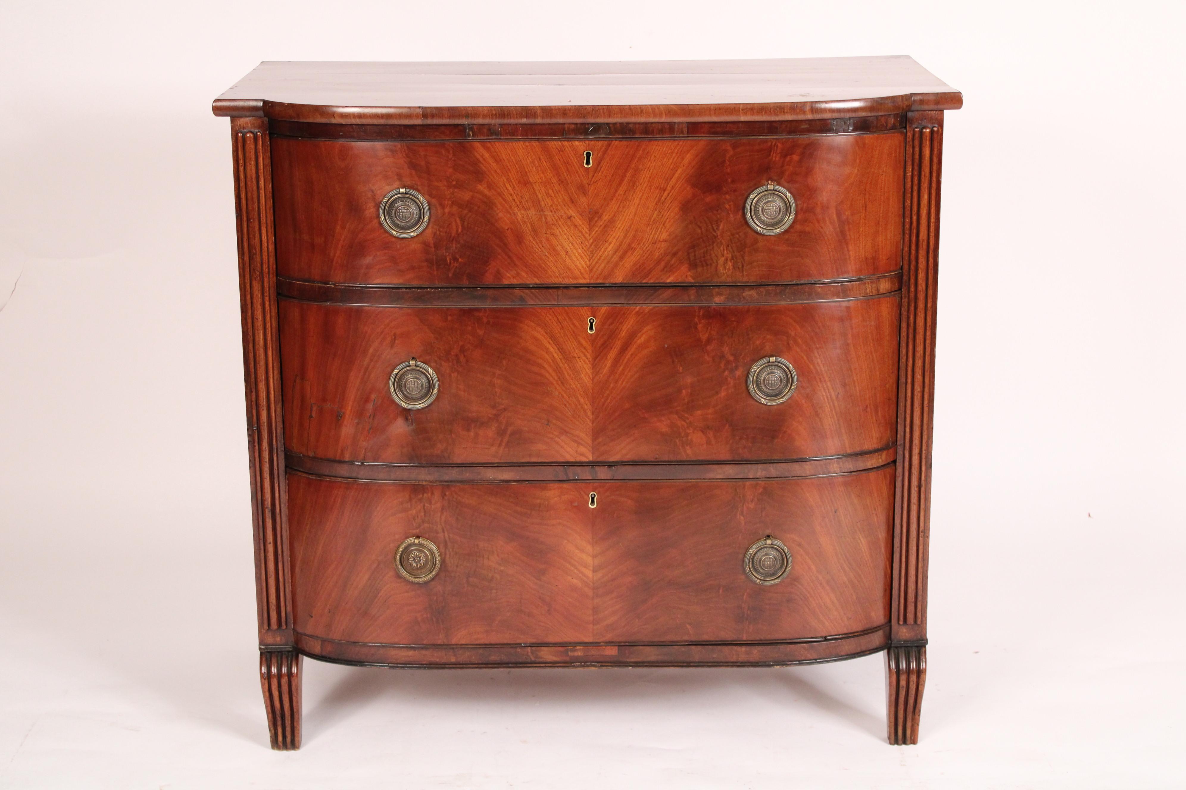 English regency mahogany bow front chest of drawers, circa 1810. With a single board top, 3 flame mahogany drawers with brass hardware, resting on slight serpentine shaped feet.
