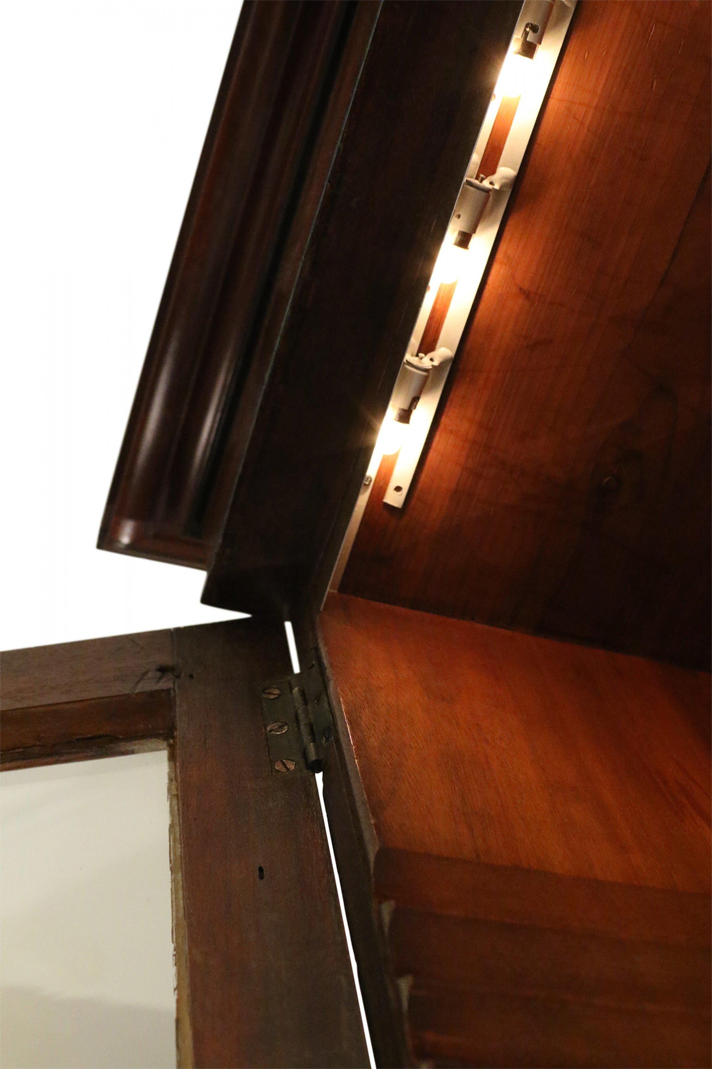 English Regency mahogany breakfront cabinet with four lower cabinets with decorative wood inlay and four upper lattice glass cabinets with under-shelf lighting.
 