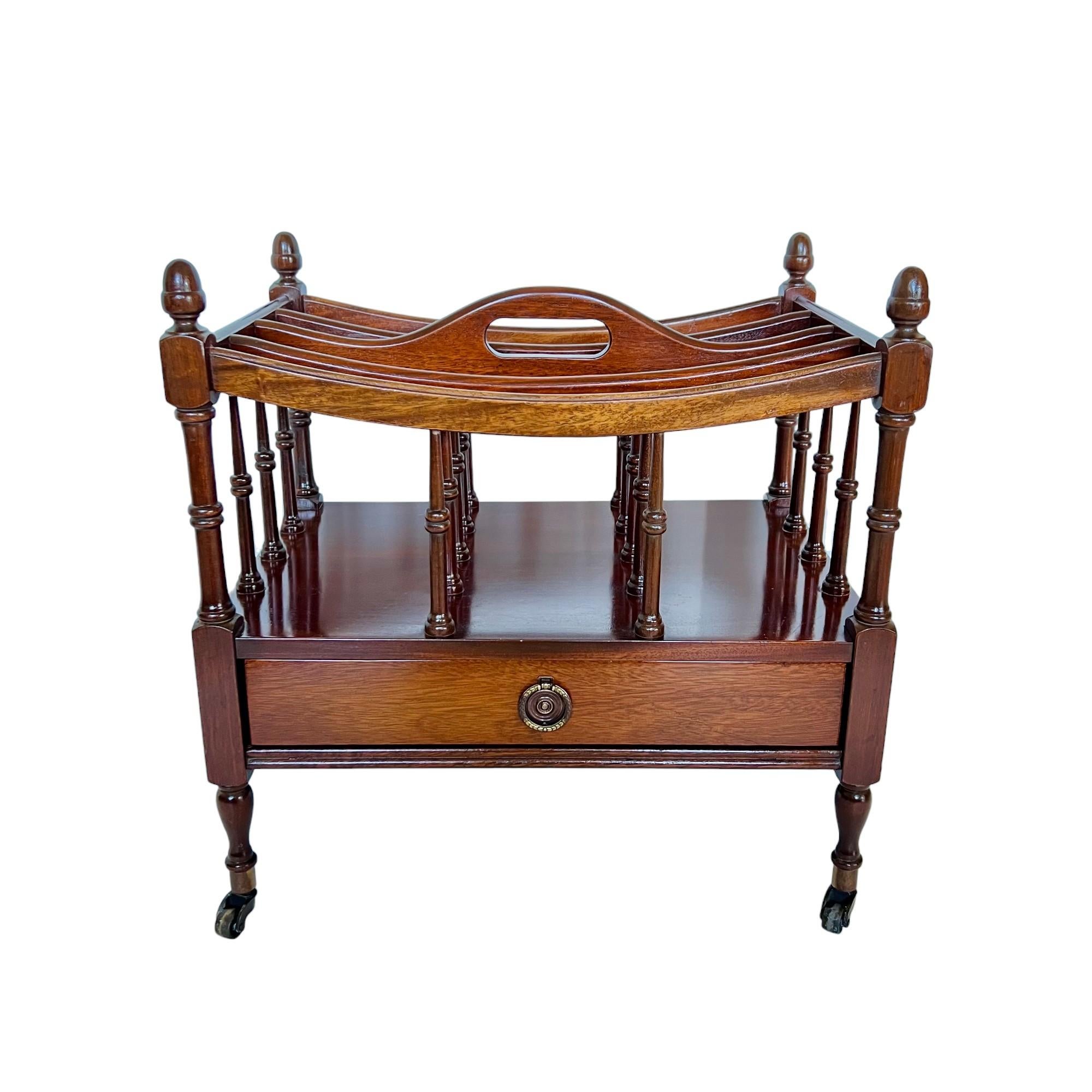 This lovely vintage English Regency style Canterbury magazine or sheet music rack is finely crafted of mahogany and features a single drawer with a brass ring pull, turned wood details and brass casters.

Dimensions: 19