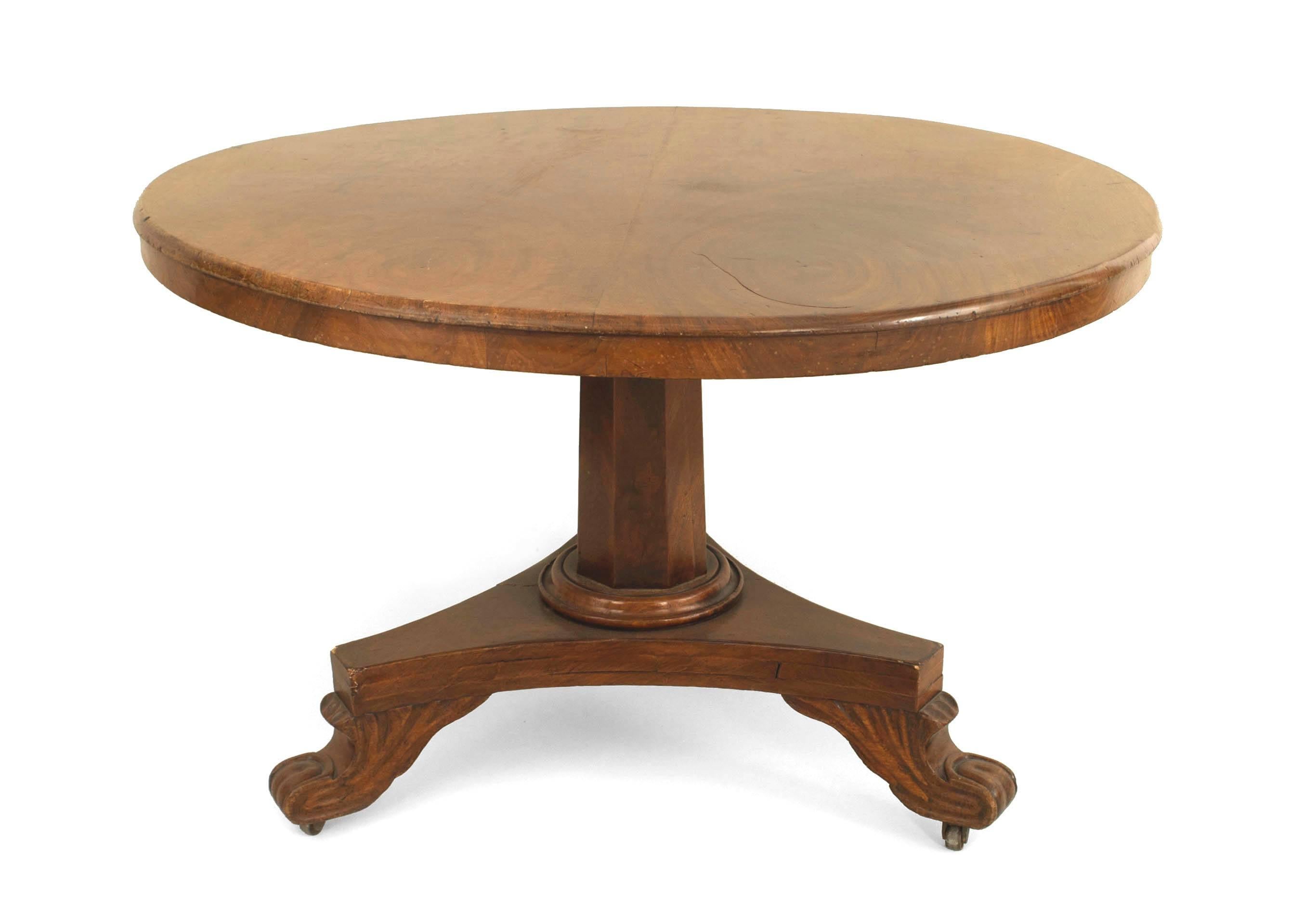 English Regency mahogany center table the bookmatched top with short apron supported by a central 6 sided pedestal column resting on a triangular base with claw feet, prior rePair to base.
