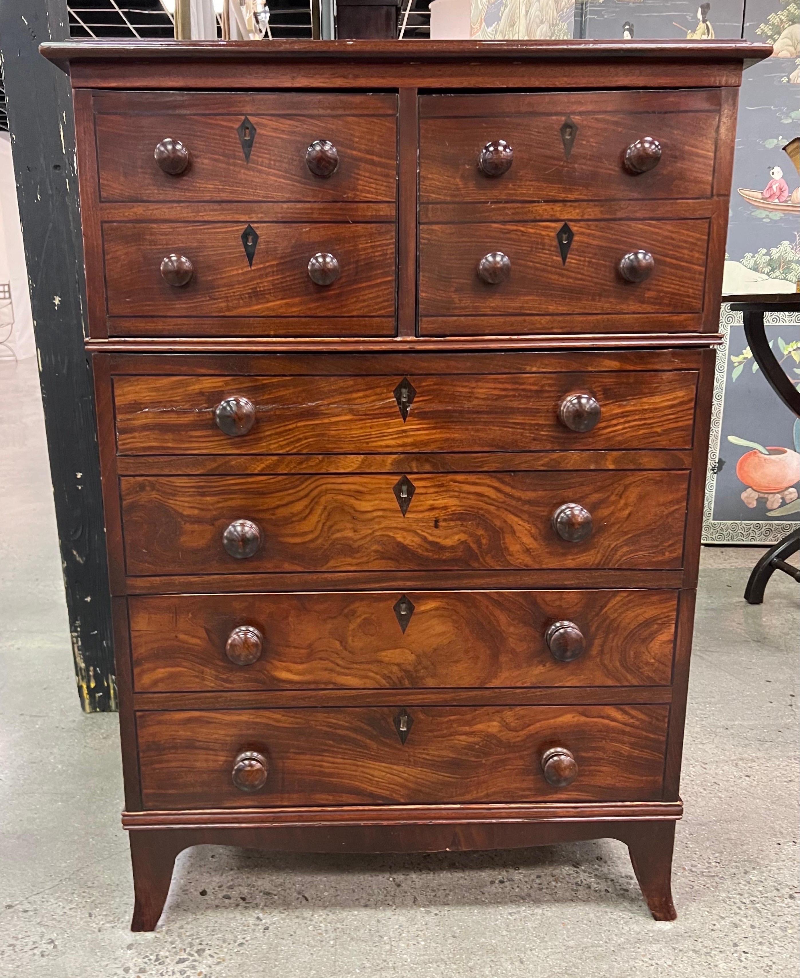 Handsome English Regency mahogany chest with ebonized details. This chest has two half drawers over two full drawers made to look like four half drawers over four full drawers. The eschuteons and border are ebonized and the piece sits on lovely