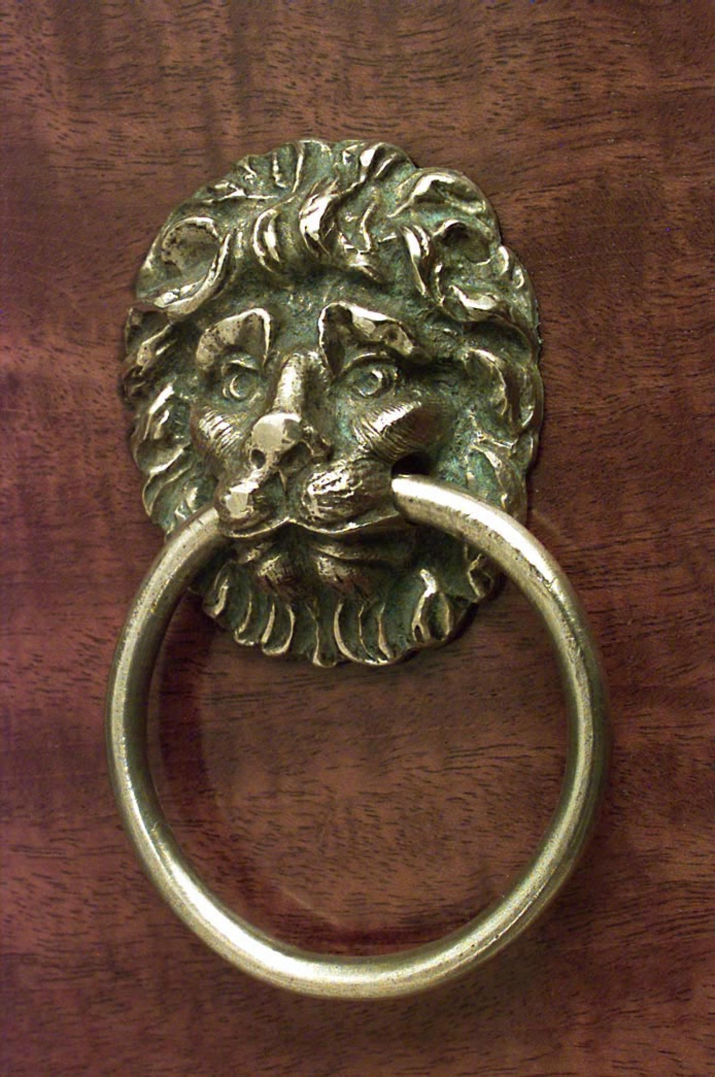 Cassapanca in mogano della Reggenza inglese con design frontale ad arco e maniglie a testa di leone in bronzo con intarsi ebanizzati sul piano del frontone.