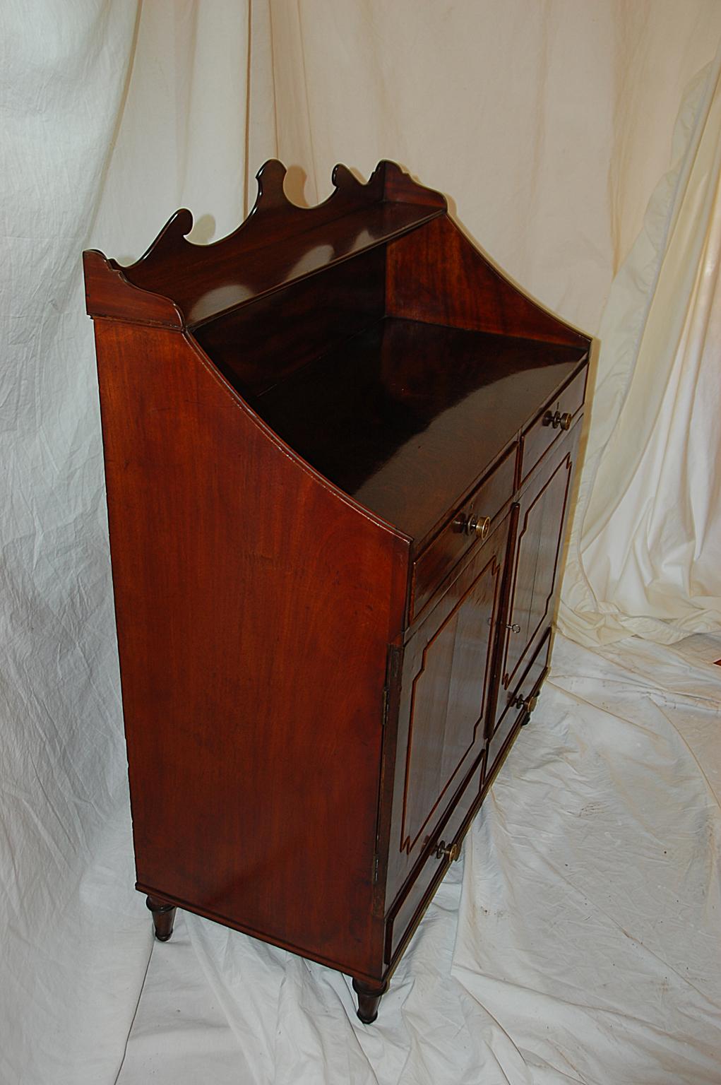 
 English Regency period flame grain mahogany four drawer chiffonier with two doors, top shelf and mahogany crossbanding. This handsome period cabinet can be used in many different capacities. Most commonly it is used as a dry bar with room for