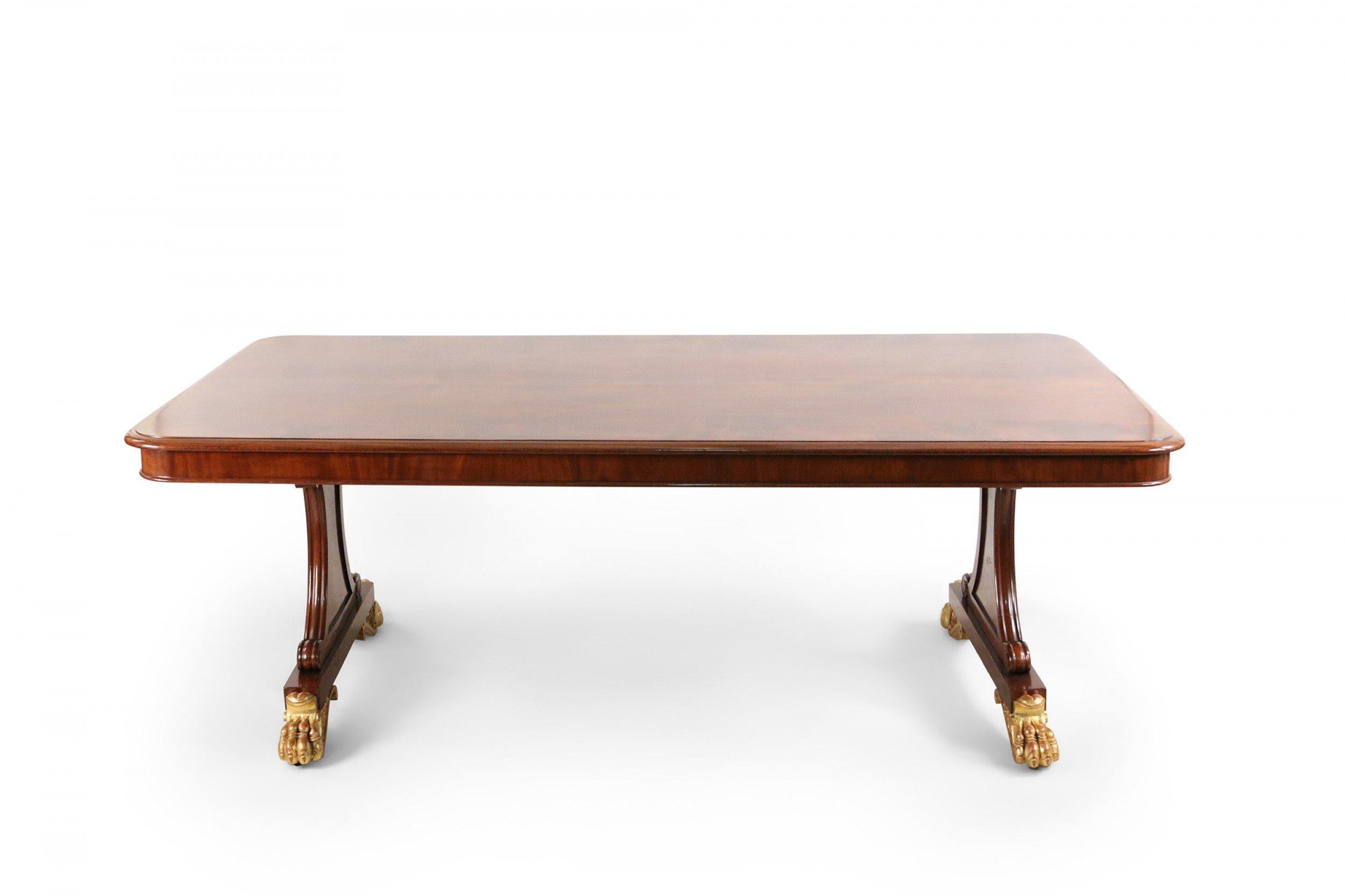 English Regency mahogany double pedestal side rectangular dining table with gilt claw feet.