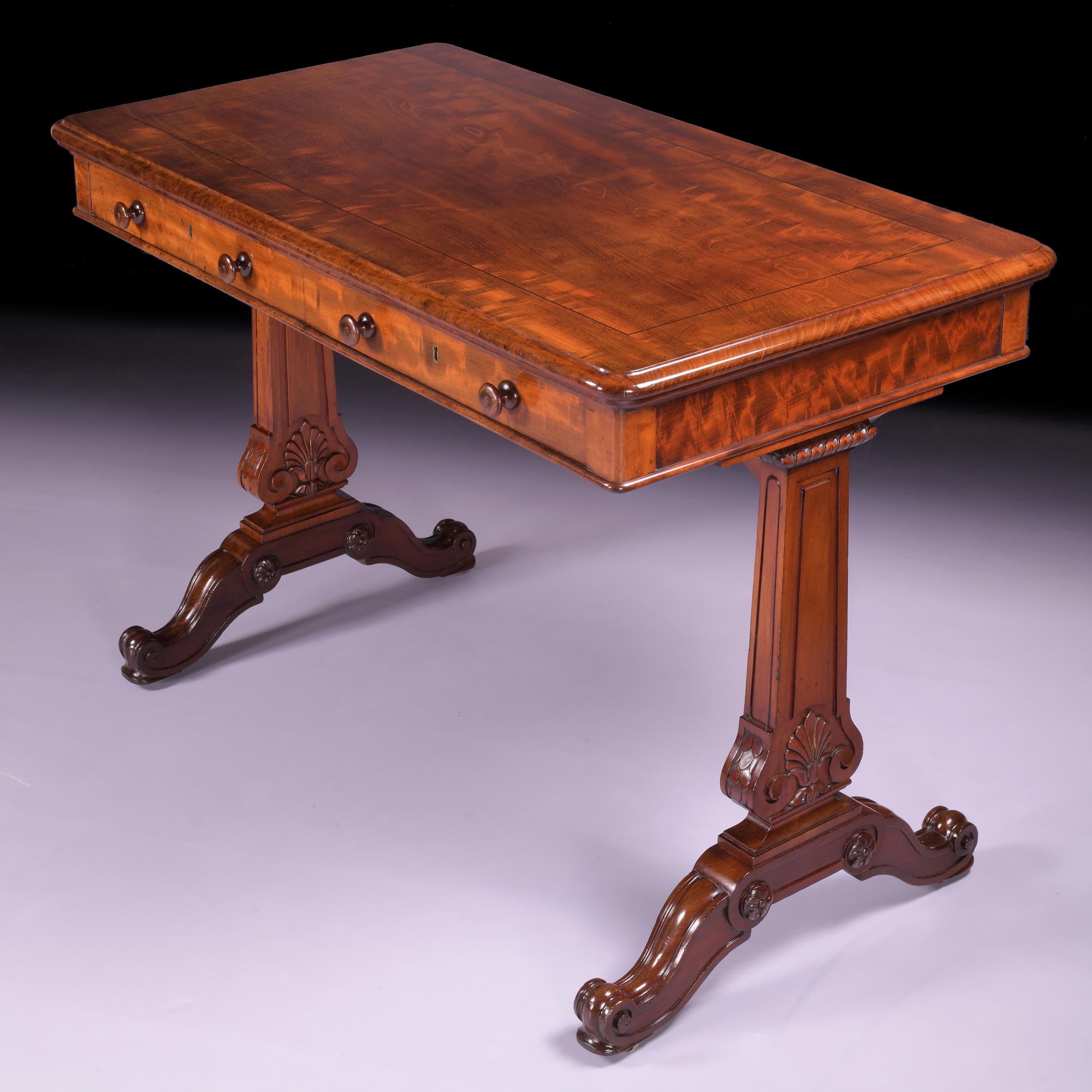A very fine English regency mahogany library writing table by Holland & Sons, the top with a moulded edge above a pair of frieze drawers, raised on tapered end supports carved with Anthemions, on scrolled trestle bases with sunken brass castors,