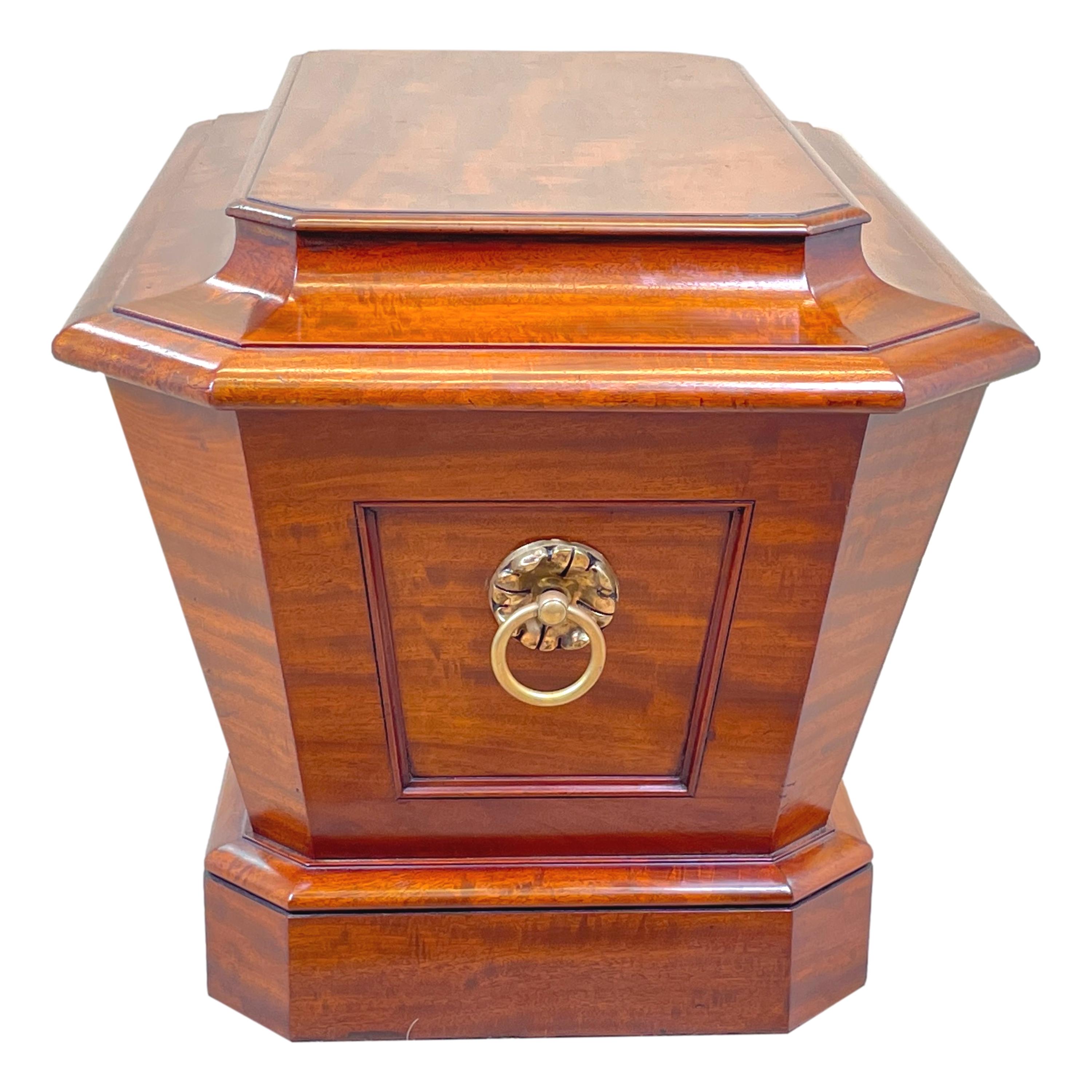 A fine quality regency perioid mahogany sarcophagus shaped wine cooler, or cellarette, retaining original brass carrying handles and fine colour throughout, raised on original plinth base.

The choice of veneers used in this beautiful wine cooler