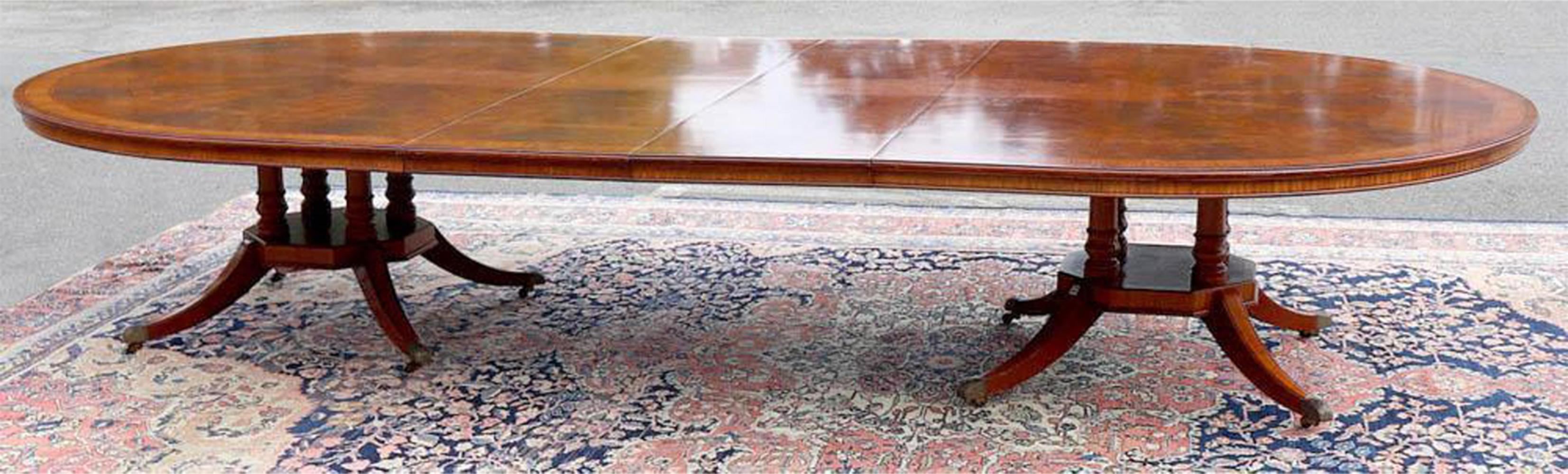 Cette table de banquet et de salle à manger de style Régence anglaise est composée d'acajou et son plateau est incrusté de bois satiné. La table est dotée d'une fonction extensible, ce qui lui permet de s'adapter sans effort à divers besoins en