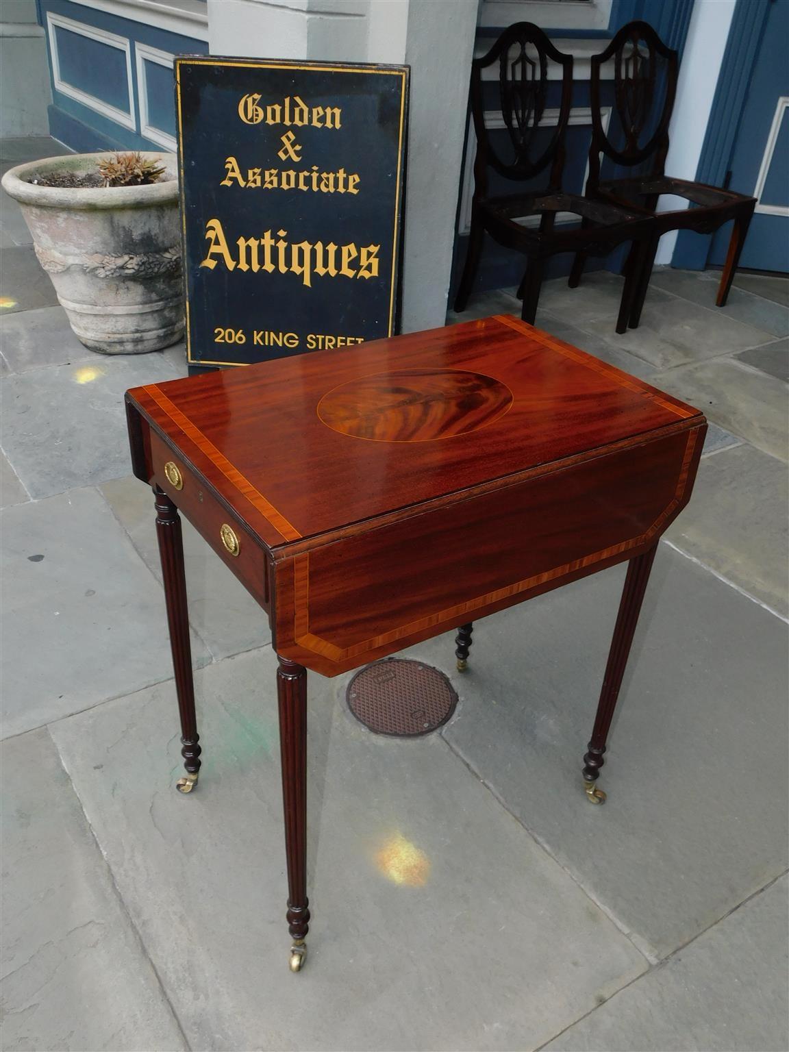 English Regency mahogany drop leaf pembroke table with satinwood string inlay, tulip wood cross banding, original oval brasses, and resting on turned bulbous reeded legs with the original brass casters, Early 19th century.
Table with leaves up is