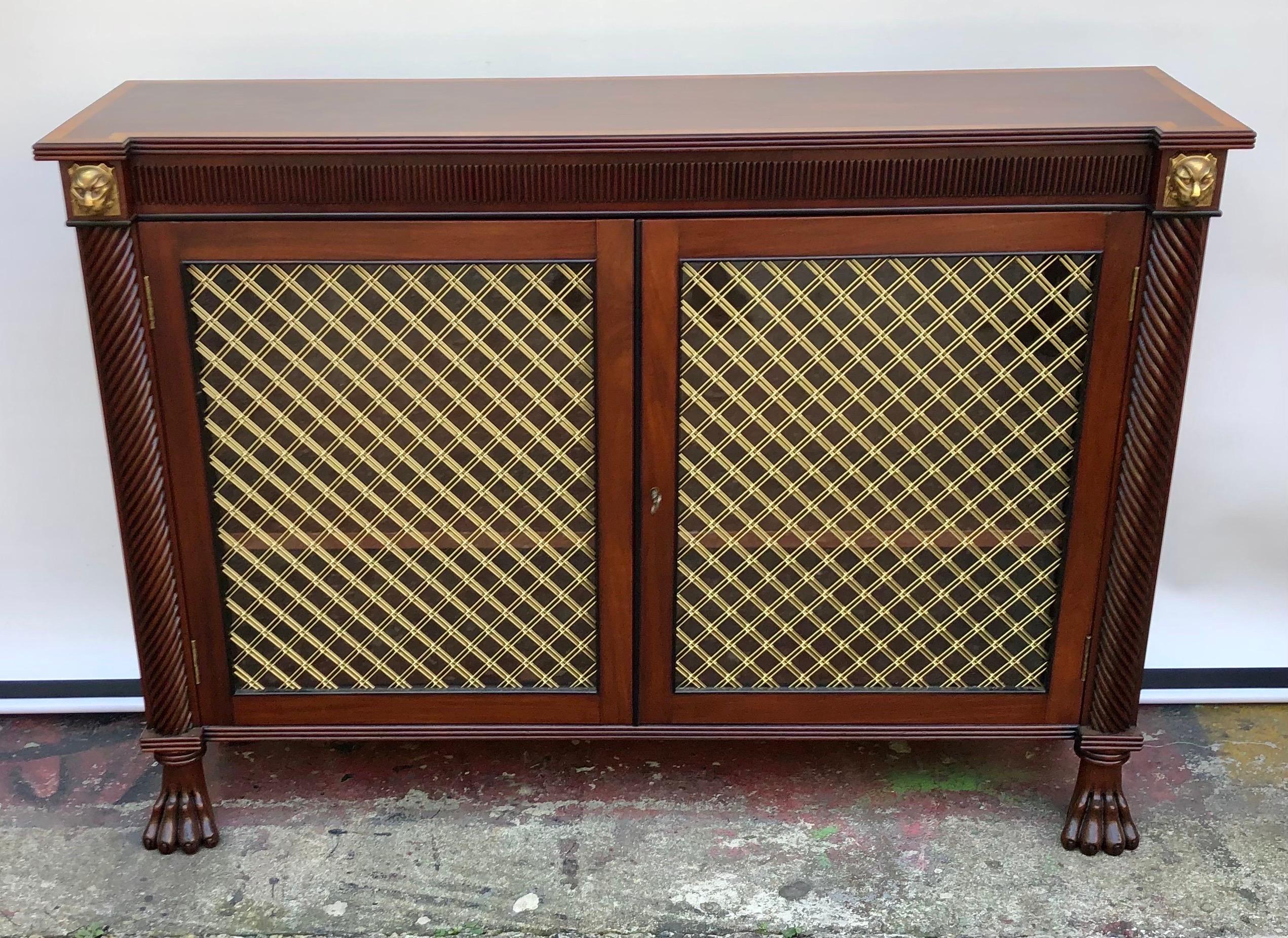 This Regal English Regency mahogany two door credenza / side cabinet is made in the early 19th Century using fine Cuban Mahogany with Gilt Bronze Mounts. The Regency Credenza top is made from one solid mahogany board with reeded edges and veneered