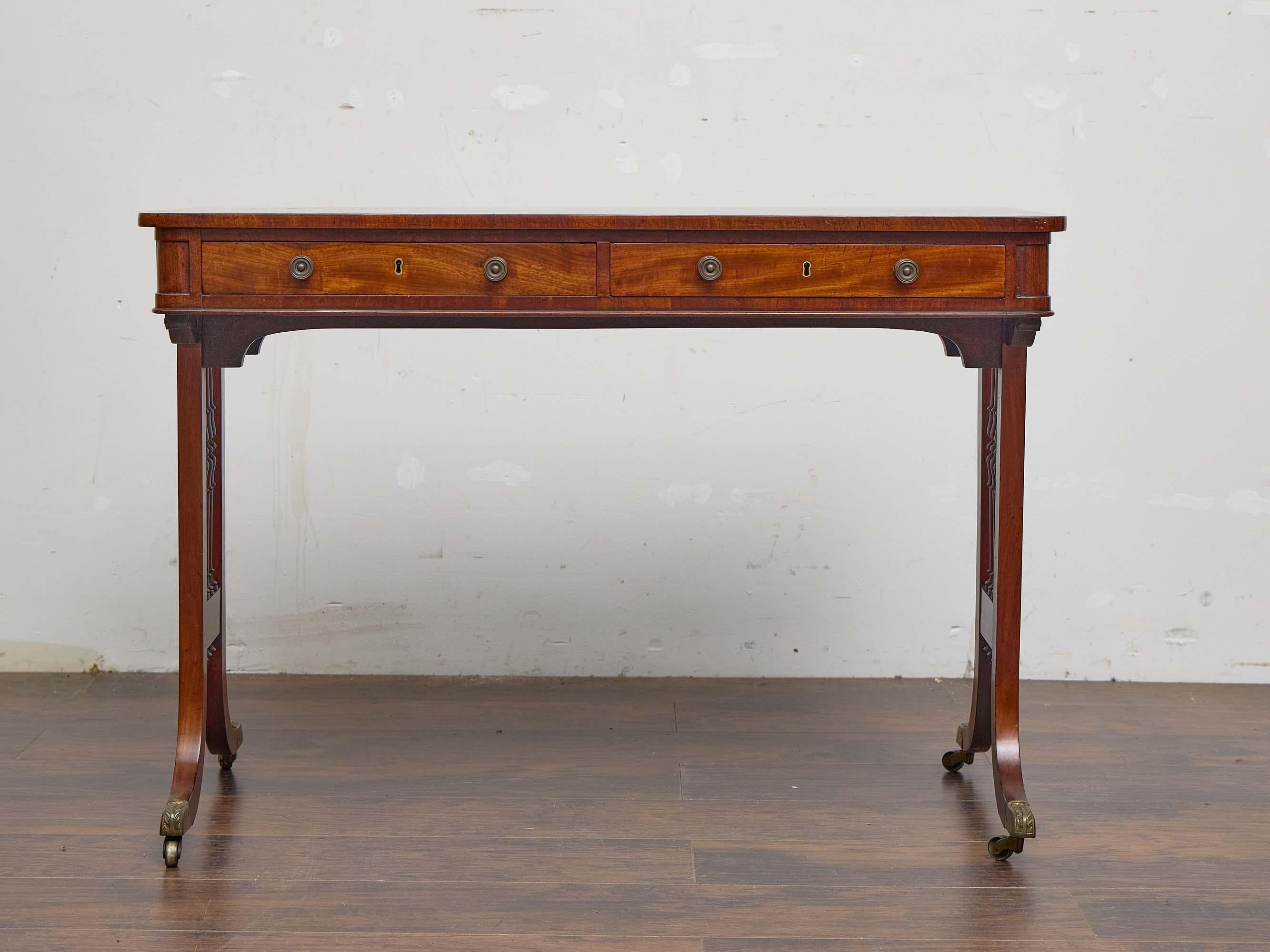 Carved English Regency Mahogany Writing Desk with Pierced Sides and Casters For Sale