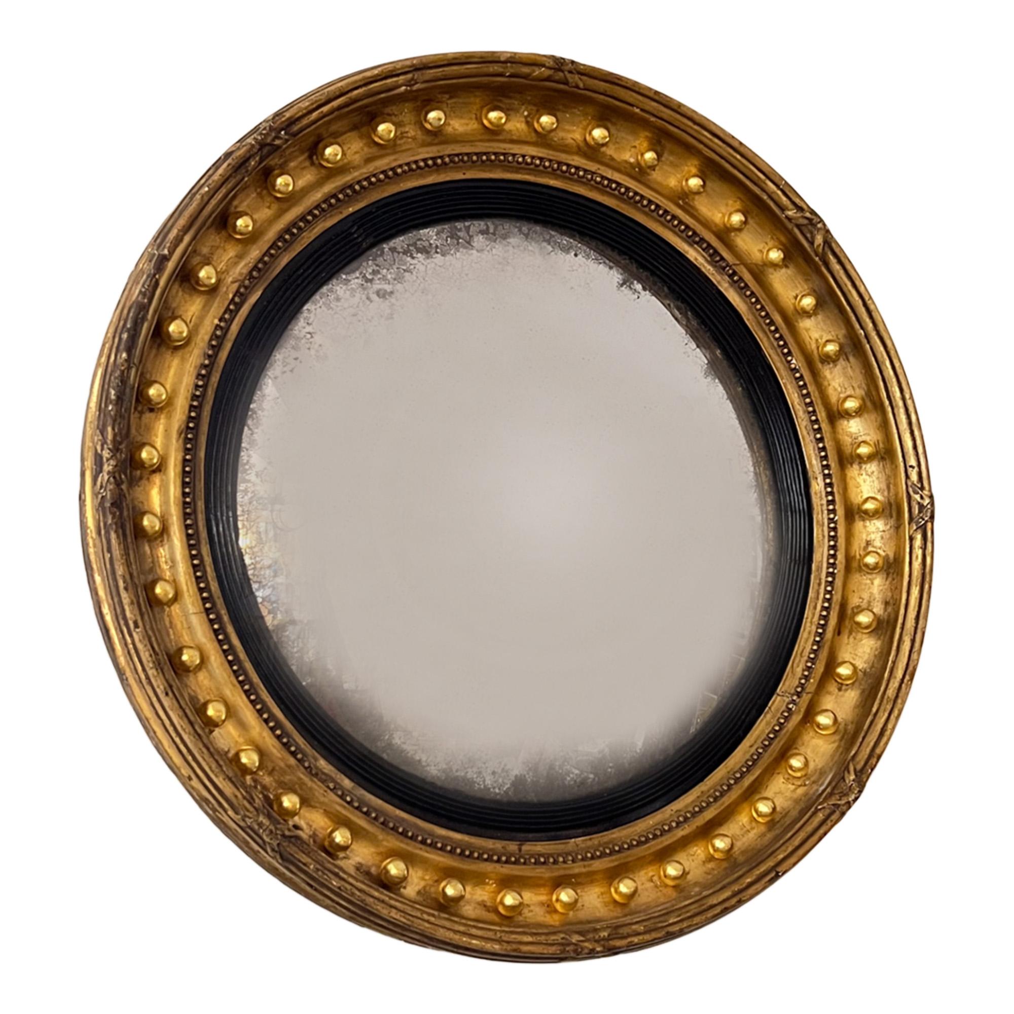 A lovely example of a traditional English Regency convex mirror. 

The giltwood frame is decorated with regularly spaced balls. The original plate is foxed around the edge and again - as is traditional - the mirror is convex. Please take a look at