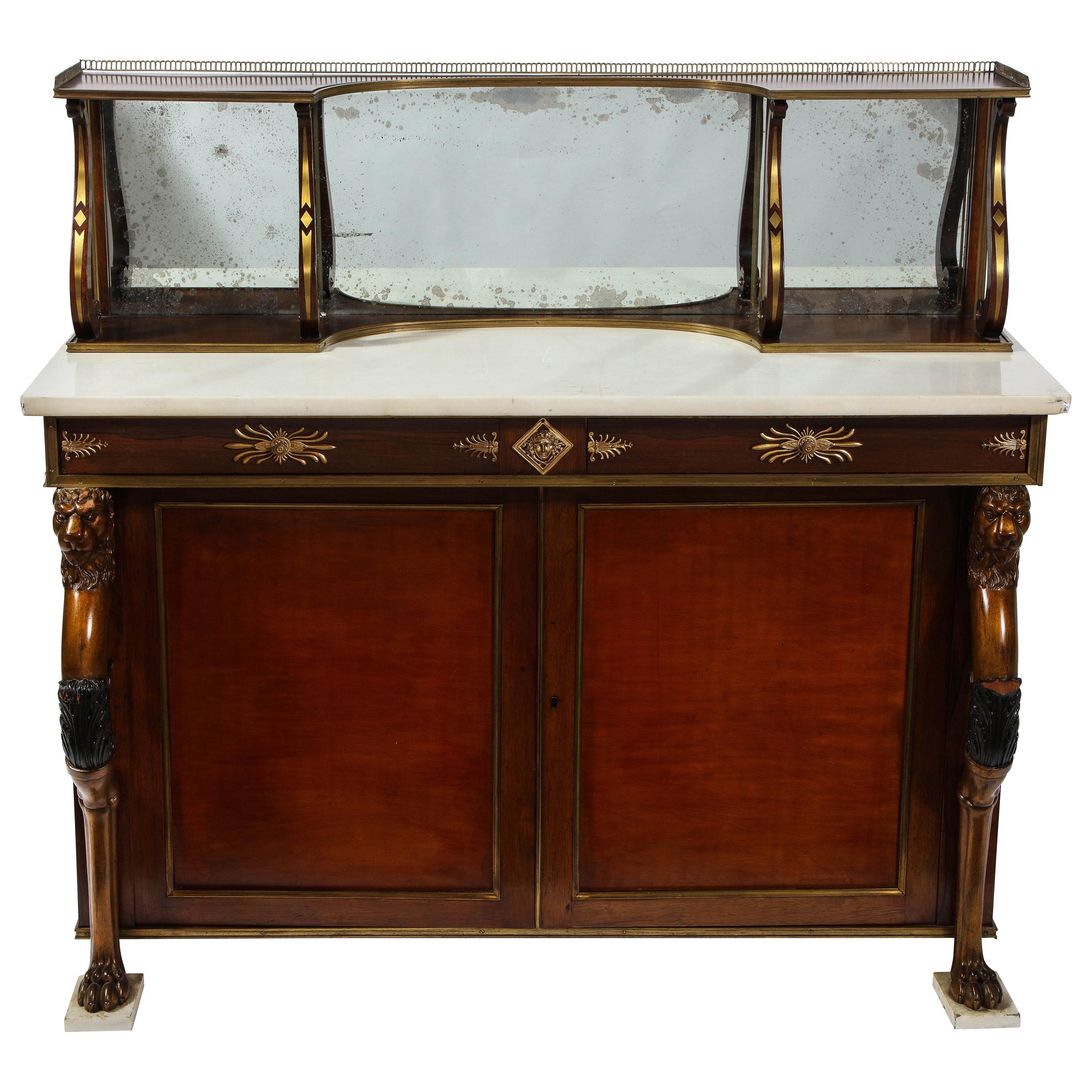 An English Regency ormolu-mounted Chiffonier/sideboard with a Carrara marble top, having hand carved figural wooden lion supports and removable lyre form mirrored shelf. This is truly an extravagant piece that can be utilized for different room