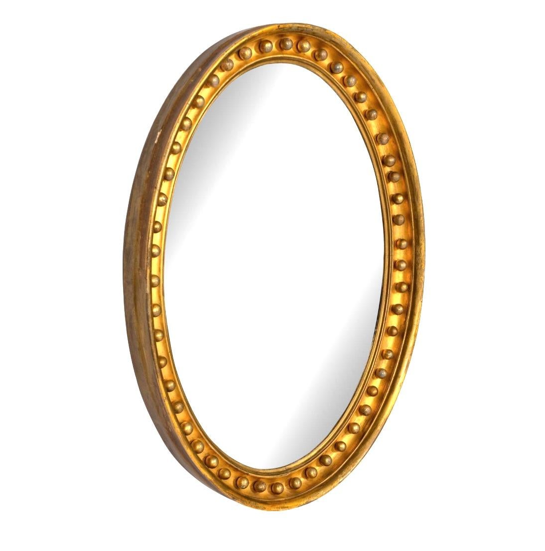 Miroir ovale en bois doré de style Régence anglaise du 19e siècle. Le miroir est orné de petites perles rondes sur le bord du cadre, une marque de fabrique de la période Regency. Ces perles dorées ajoutent de la texture et de la richesse au motif.