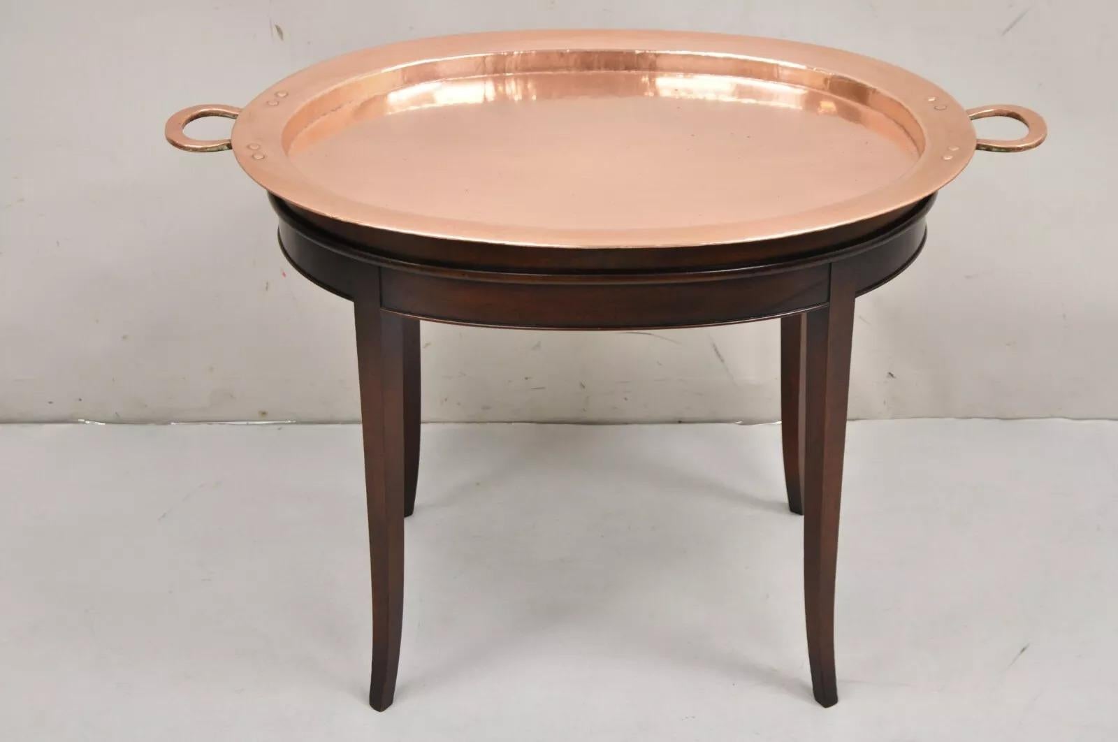 Vintage English Regency Oval Mahogany Butler's Coffee Table with Copper Serving Tray Top. Item features a mahogany base with saber legs and a stunning removable, hand hammered, polished copper serving tray top with twin handles. Circa Early 20th