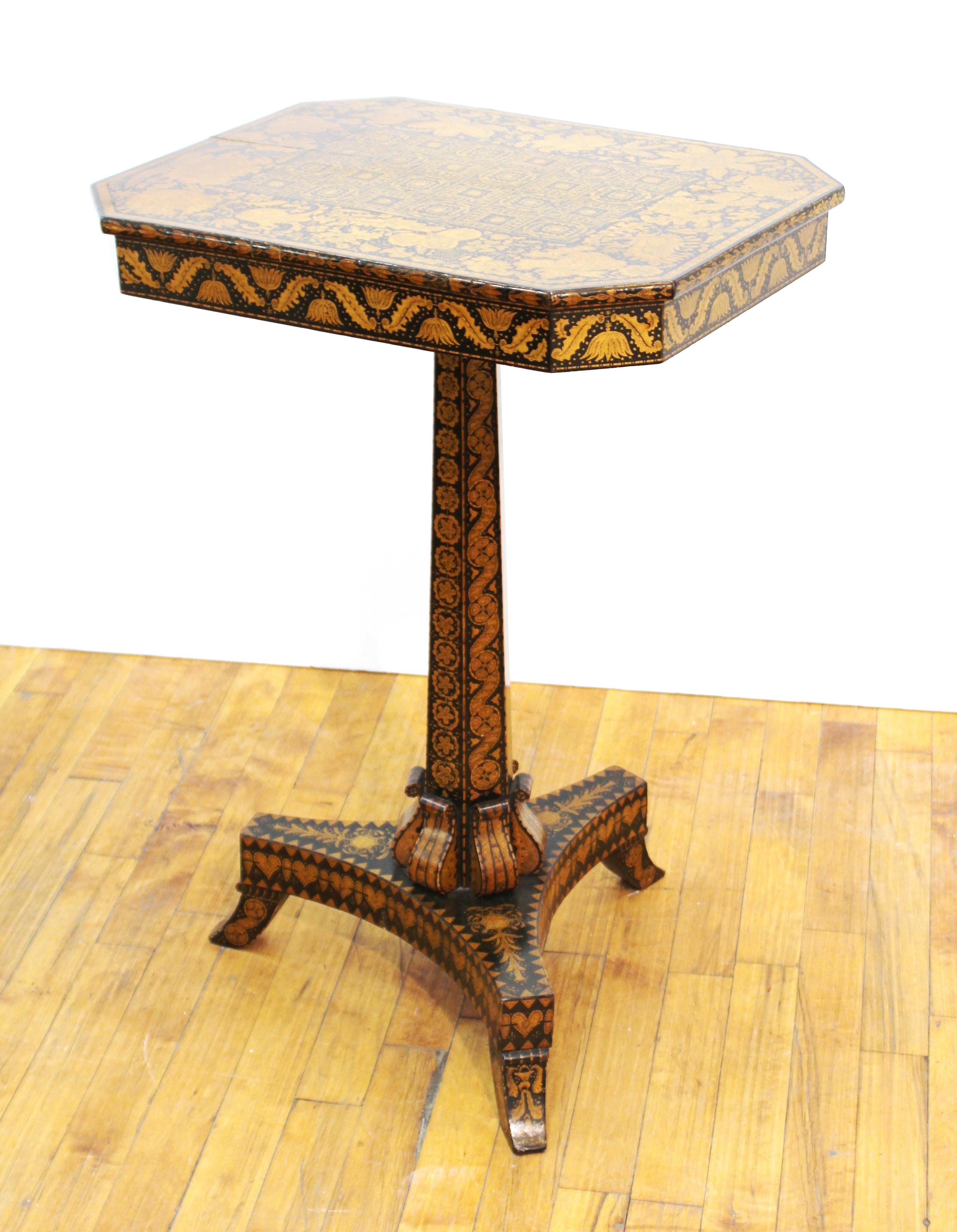 English Regency period penwork wood table with octagonal top raised on tripod base, covered in hand-drawn floral and geometric ornamental decor, circa 1815-1820.
