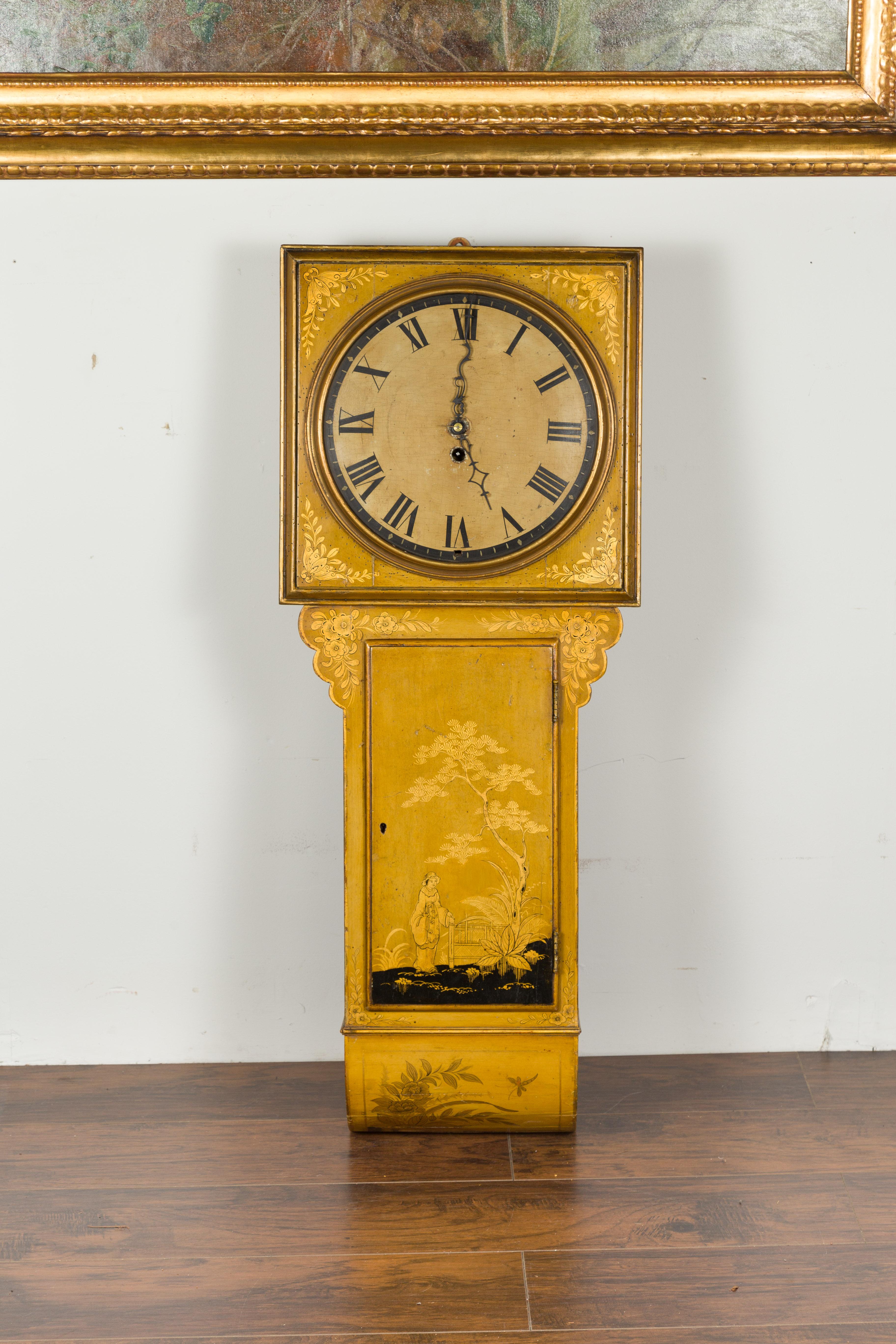 An English painted wood wall clock from the early 19th century, with chinoiserie motifs. Created in England at the end of the Regency period, this wall clock captures our attention with its golden tones and chinoiserie décor. The clock is topped