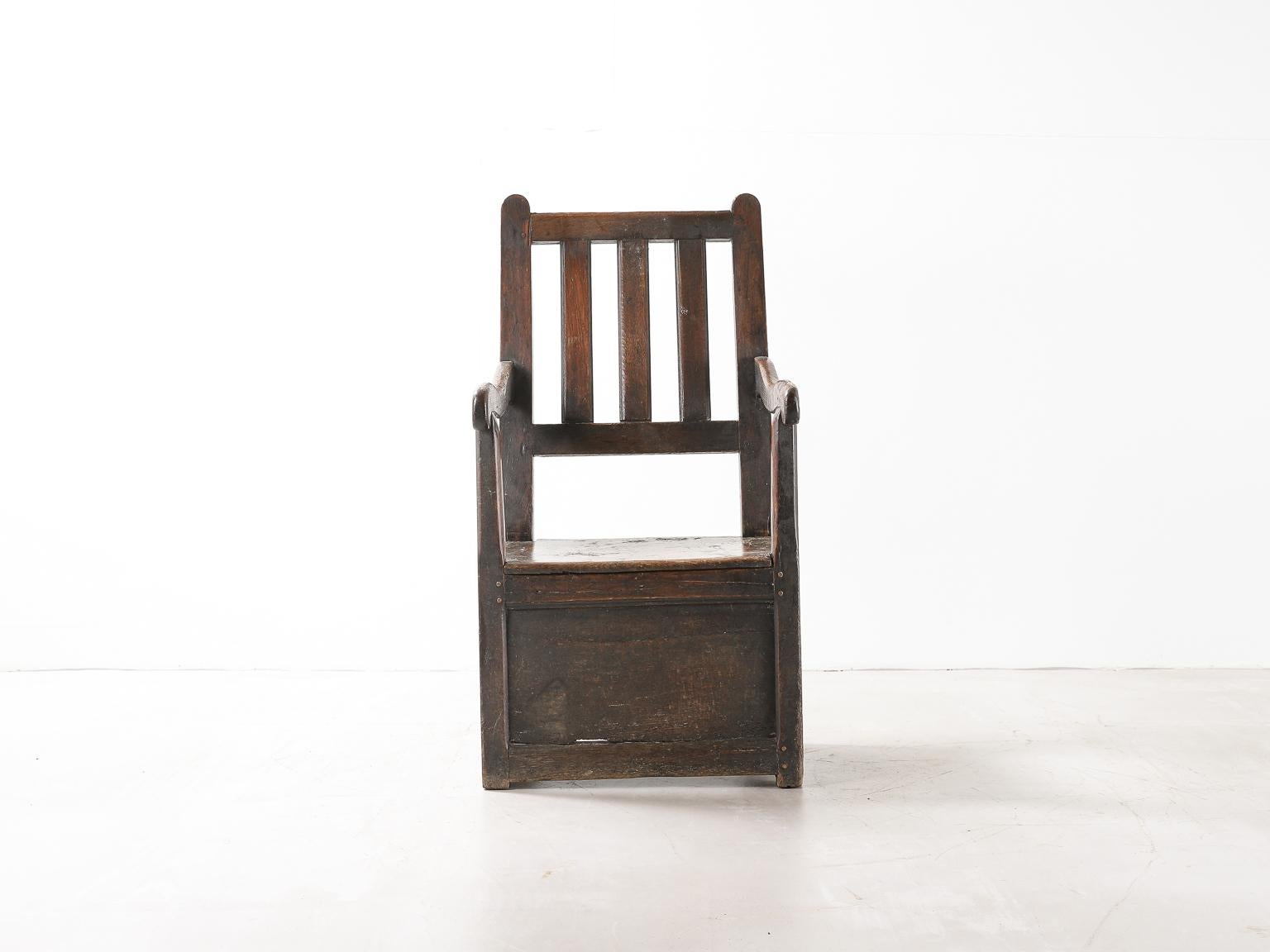 Ein Sessel aus dunklem Holz aus der Regency-Zeit mit Stauraum unter dem Sitz. Schöne Patina durch und durch. 