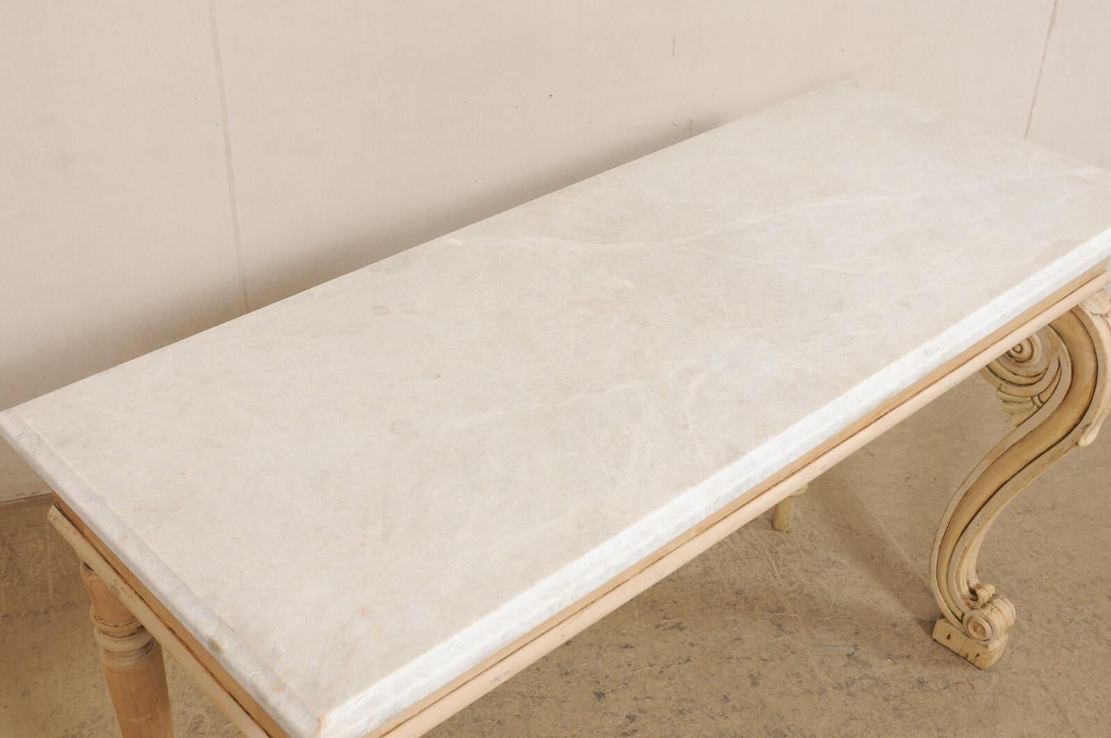 An English Regency carved and bleached wood console table, with new marble top, from the early 19th century. This antique table from England has a new/custom rectangular-shaped marble top with beveled edging, which sits upon a cleanly designed apron