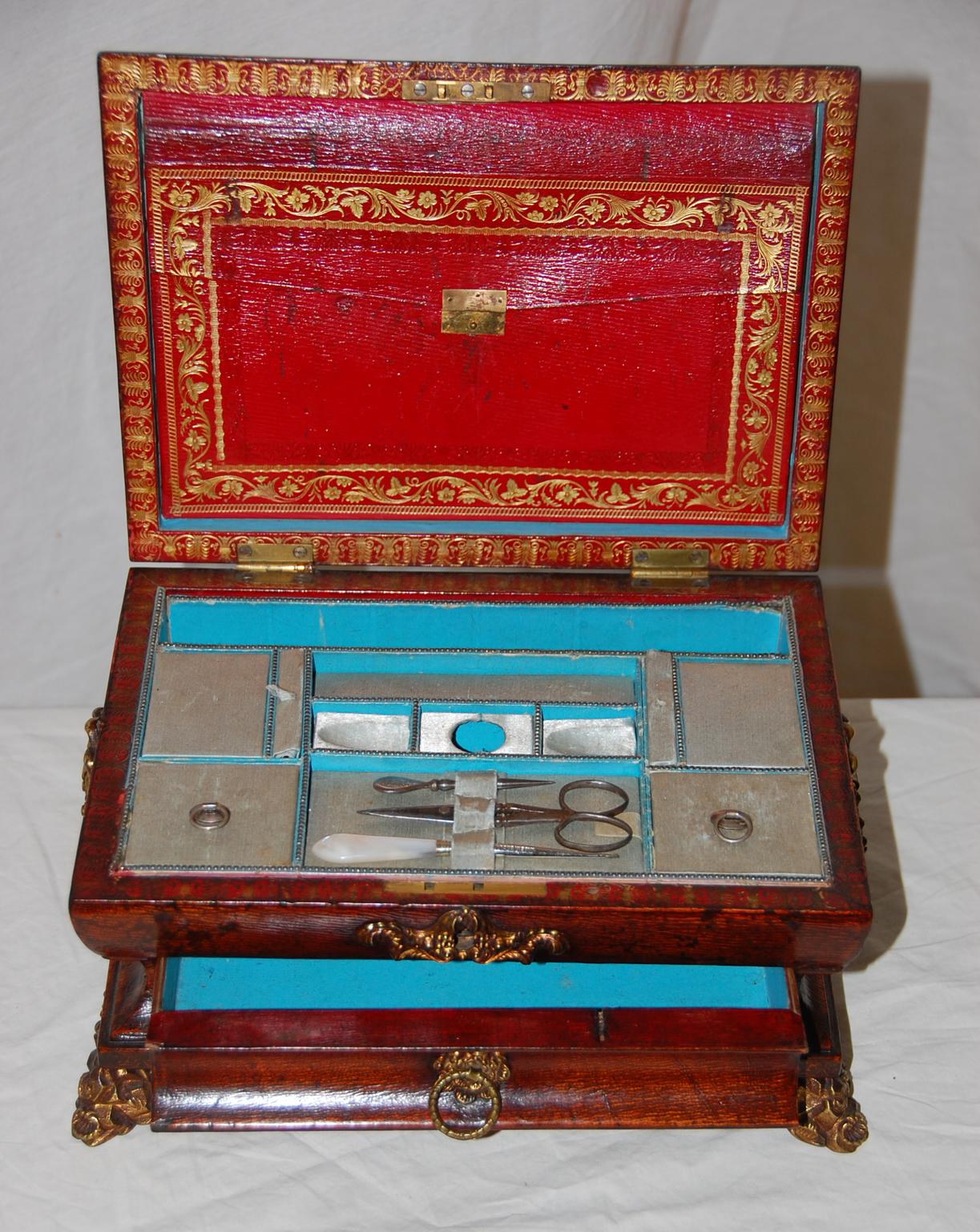 English Regency period embossed leather fitted sewing box with drawer and original brass handles, feet and mounts. When the lid is lifted there is a red leather embossed envelope which opens for discrete storage in the lid, the interior is fitted