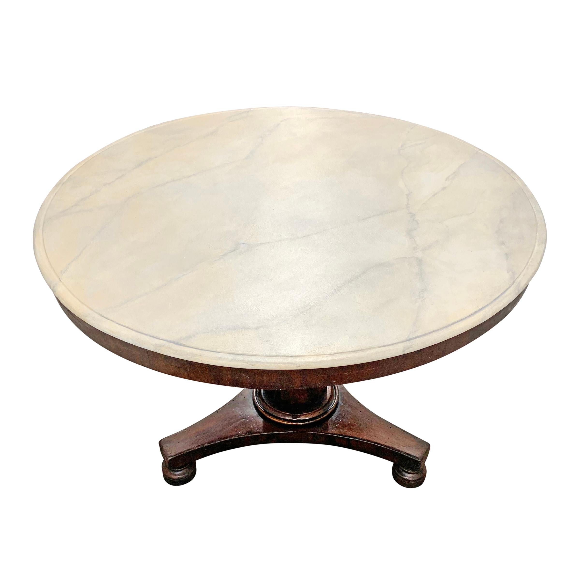 A sophisticated early 19th century English mahogany center table with a faux painted white marble top supported on a tapered hexagonal column resting on three legs with bun feet. Table is also a perfect size for use as a breakfast table.