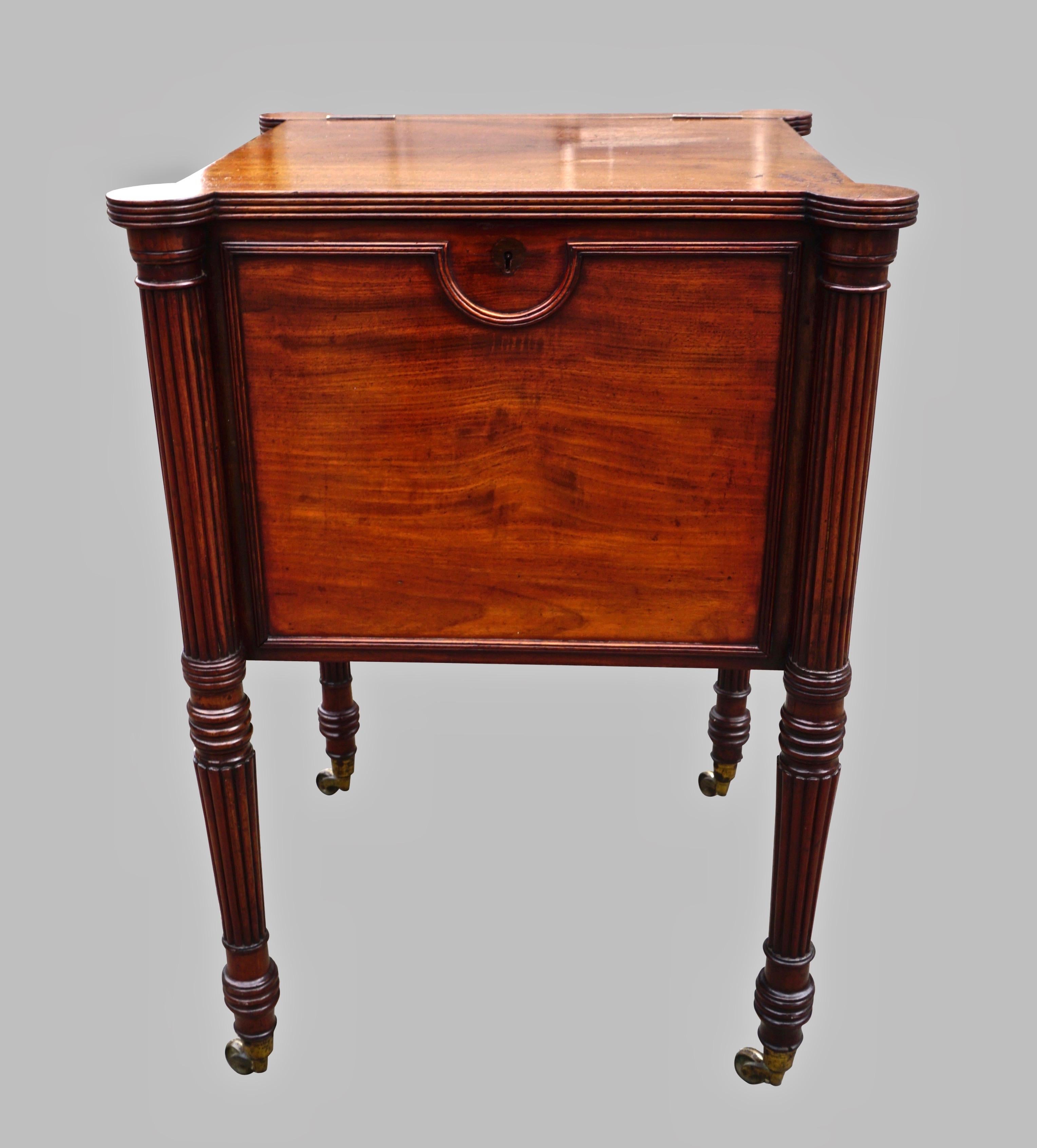A fine quality English early nineteenth century cellarette in the manner of Gillows, made of the finest matched solid mahogany timber, the shaped top opening to reveal 2 covered compartments, the reeded legs ending in brass caps retaining their