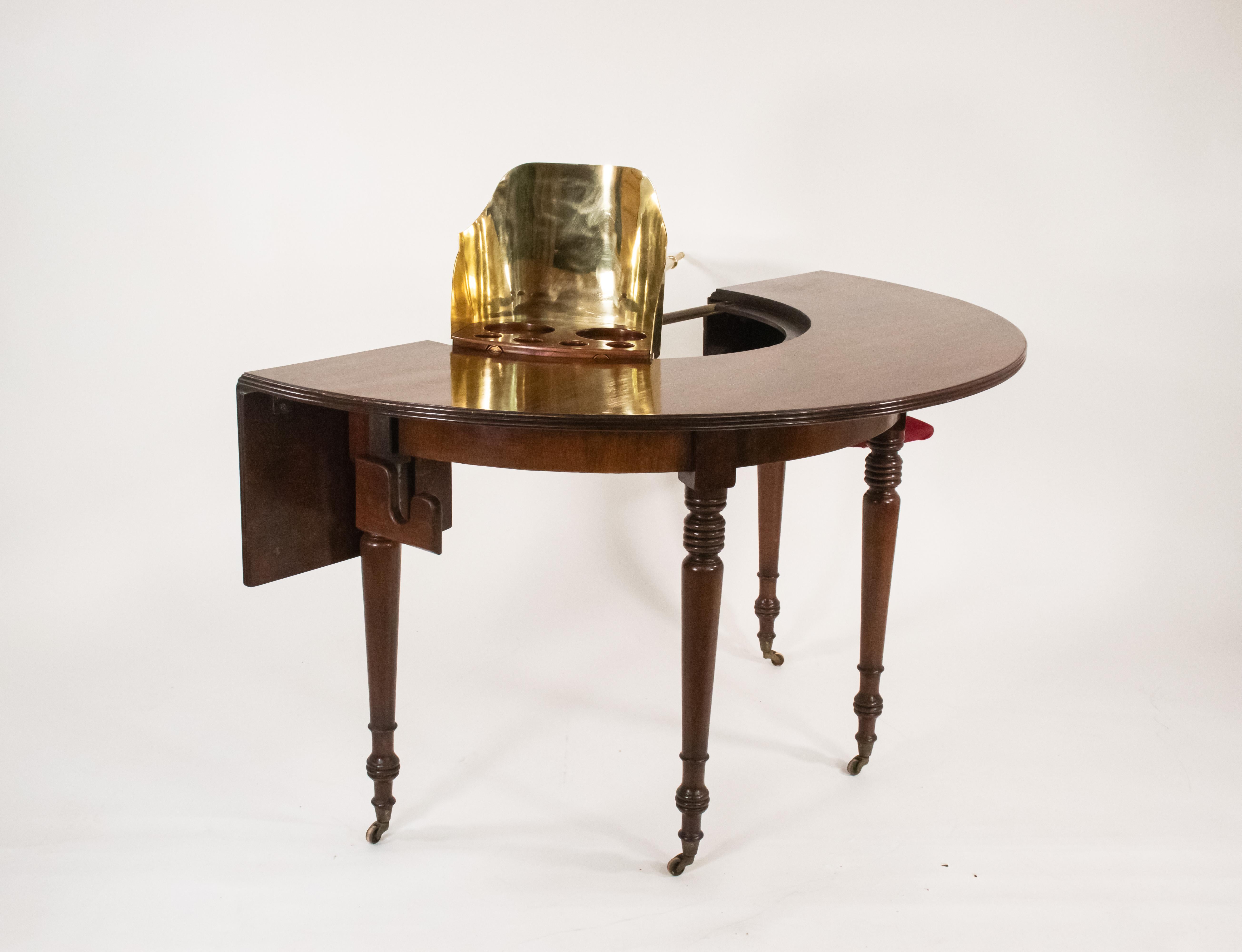 Dieser exquisit gefertigte Mahagoni-Hufeisentisch aus der Regency-Zeit ist ein Beispiel für die hervorragende Tischlerkunst seiner Zeit. Der aus feinem Mahagoni der Regency-Ära gefertigte Tisch strahlt eine warme Patina aus, die auf sein hohes Alter